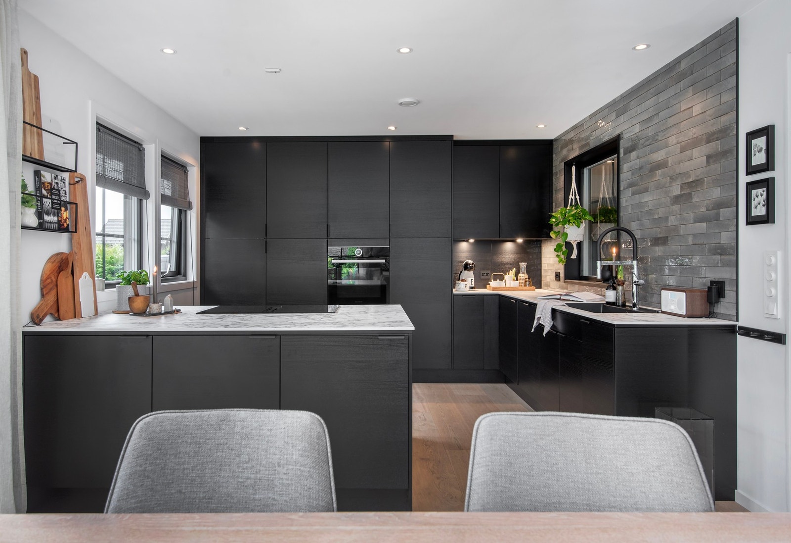 Kjøkkeninnredning fra Epoq med svart finert fronter og kompaktlaminat benkeplate med underlimt vask. Galleribilde