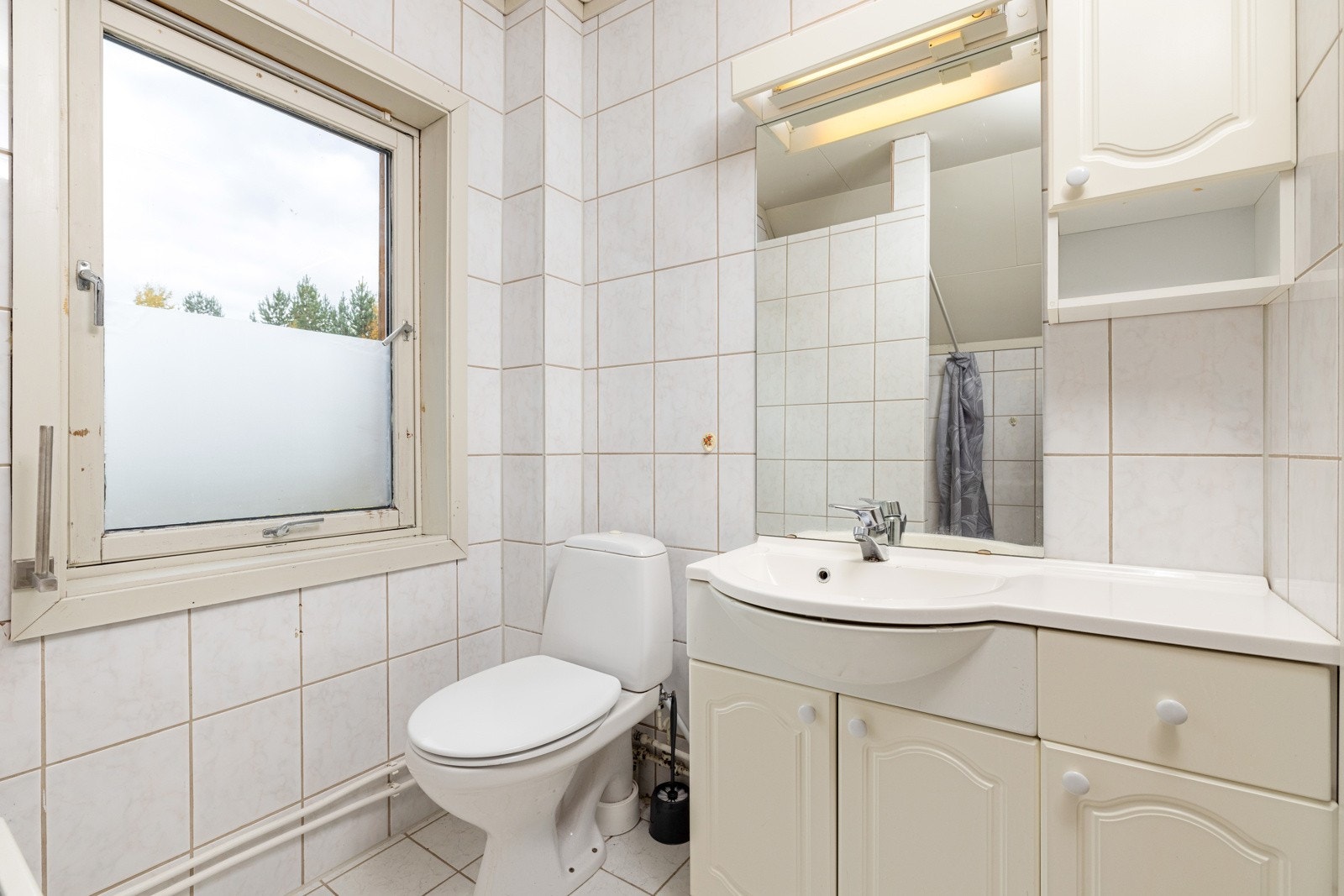 Badet i 2.etasje er innredet med toalett, servant på innredning og dusjnisje med forheng. Galleribilde