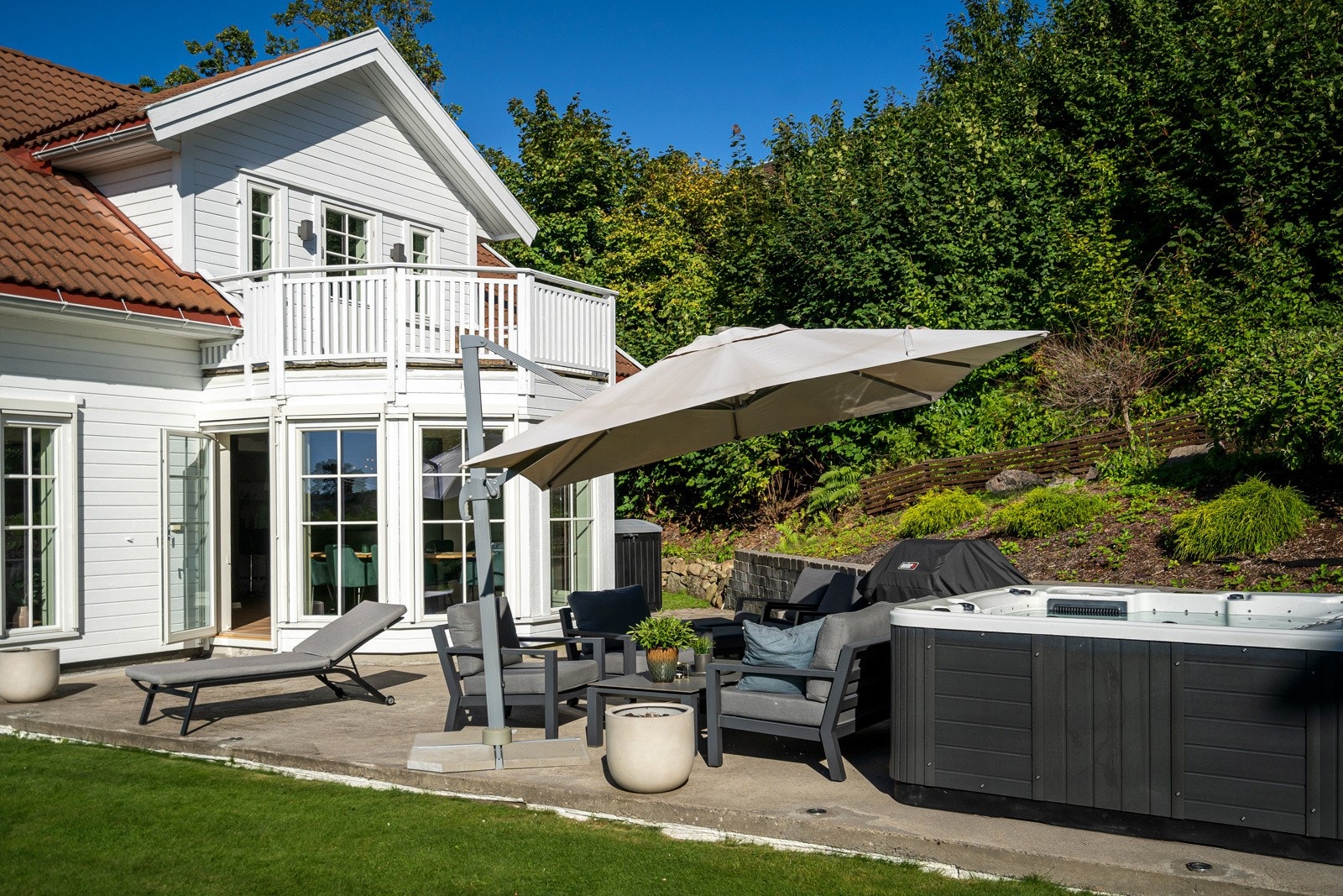 Utgang fra stuen til en lun og meget solrik terrasse med Jacuzzi Galleribilde