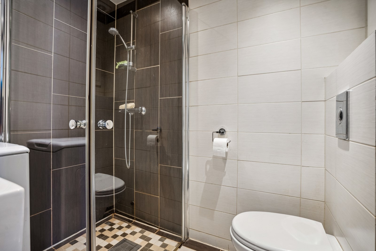 Badet er innredet med veggmonterte dusjvegger, dusj med termostat batteri, veggmontert klosett, servant med skuffer og speilskap. Galleribilde