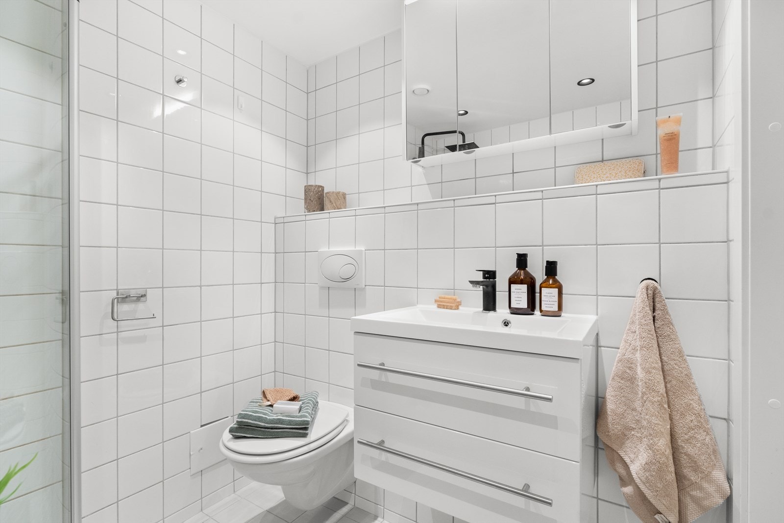 Innredningen er bestående av servant med vegghengt underskap, speil med overlys, vegghengt toalett og dusj med innfellbare dusjdører. Videre er det downlights i himling, opplegg for vaskemaskin og varmekabler i gulv. Galleribilde