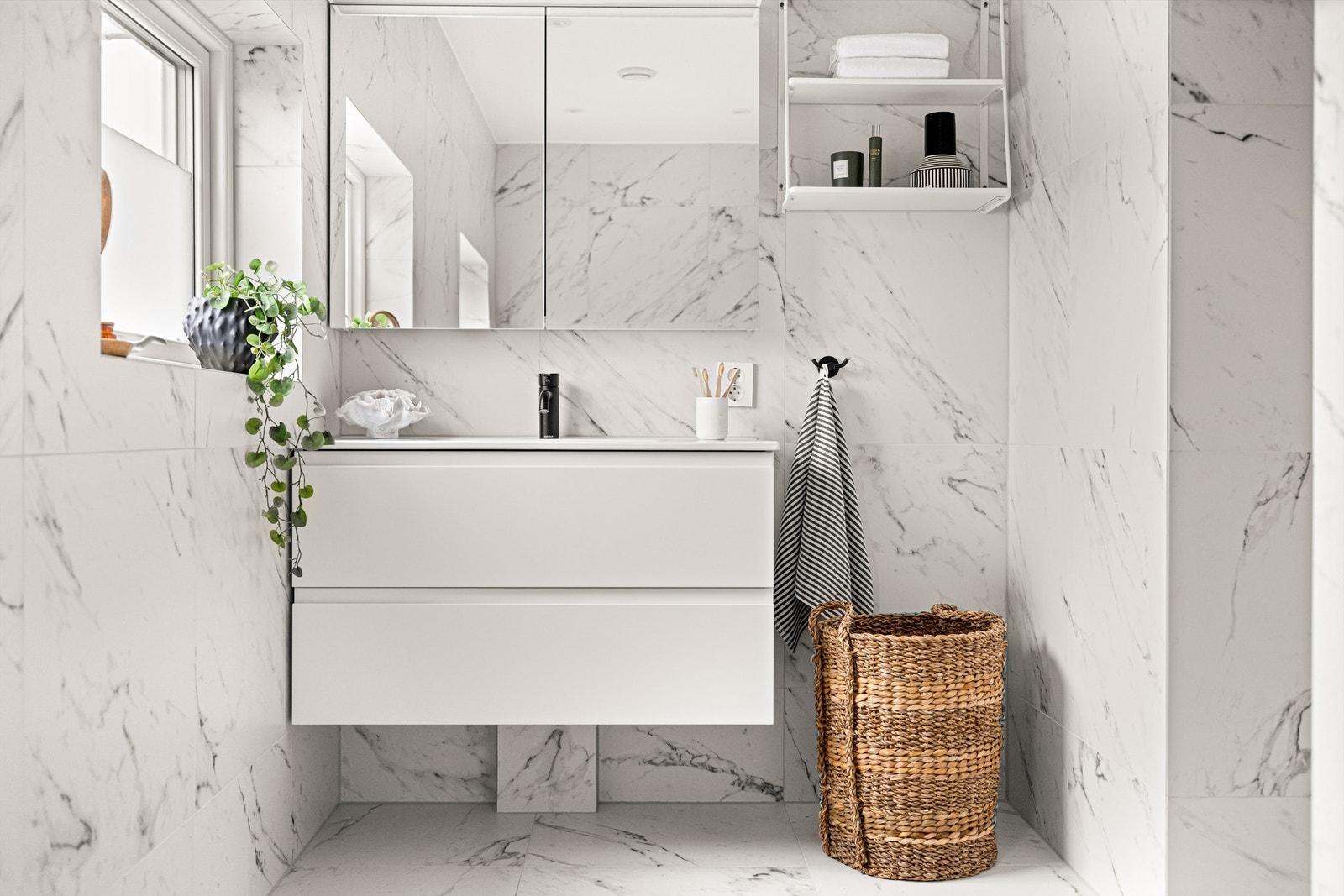 Badet er innredet med vegghengt servantskap, toalett, stor dusj og badekar Galleribilde