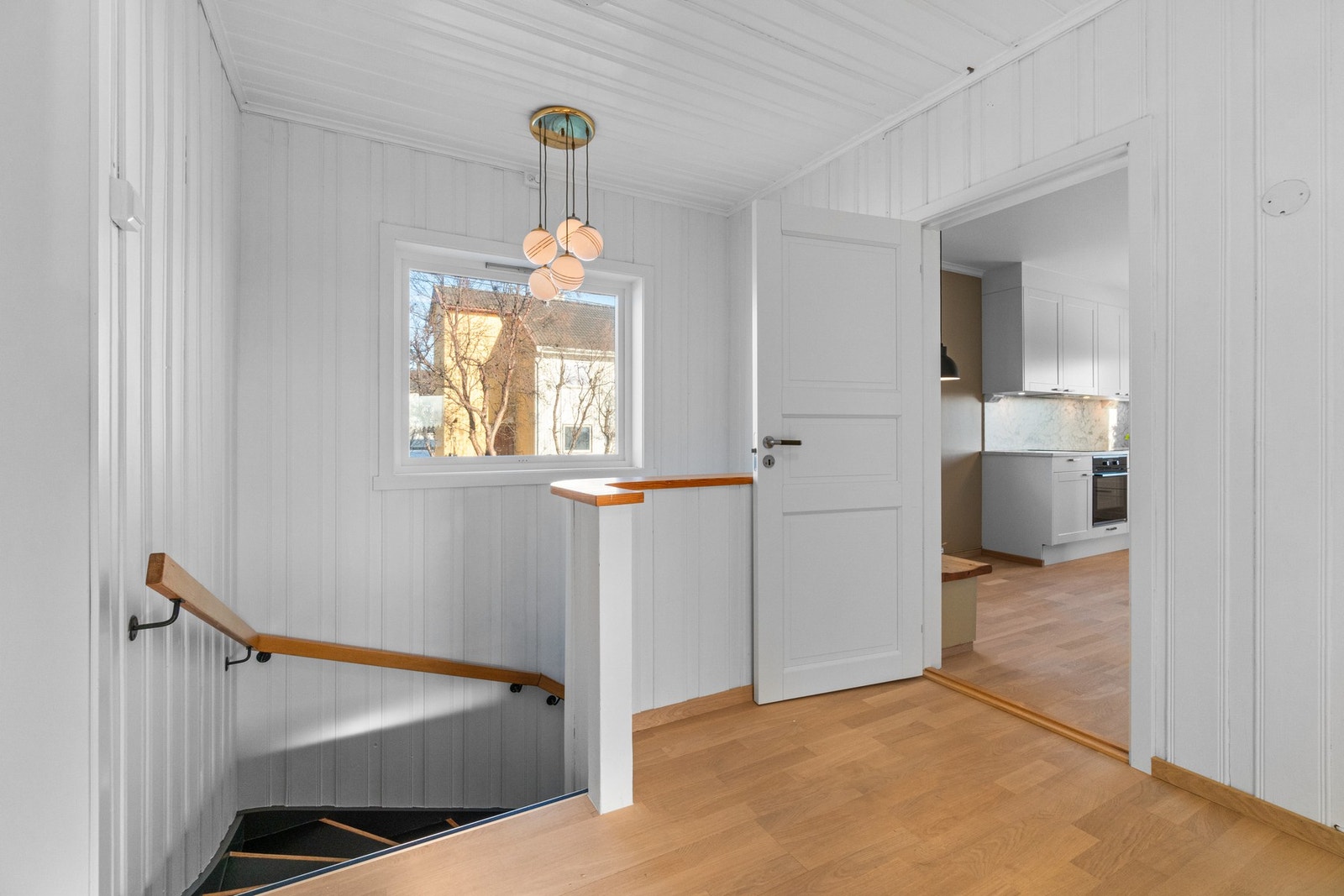 Lys og romslig trappeoppgang nærliggende kjøkken og stuer. Galleribilde
