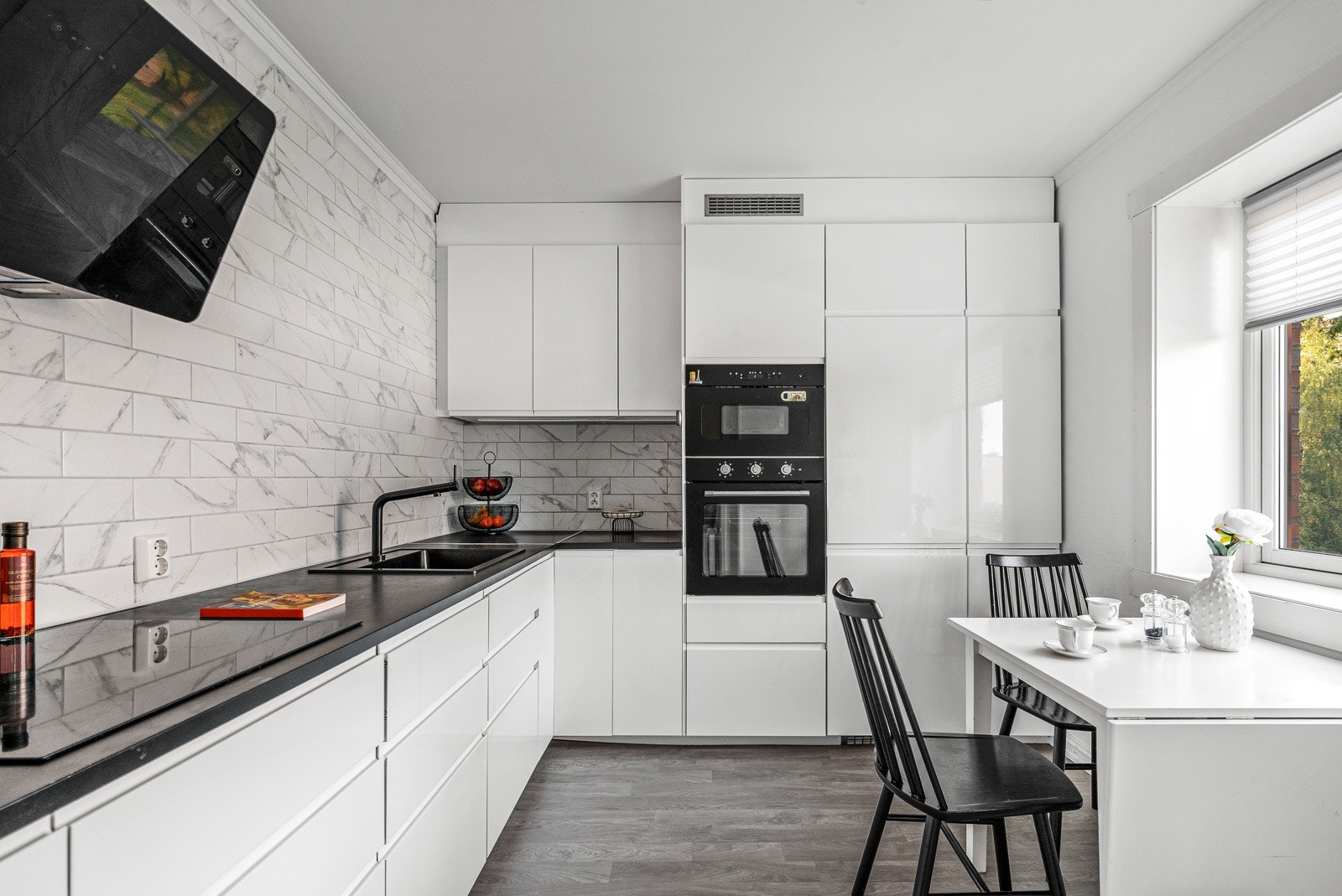 Stilig om romslig kjøkken fra 2020. Kjøkkenet er et vinkel formet kjøkken, med over og underskap med slette hvite fronter. Galleribilde