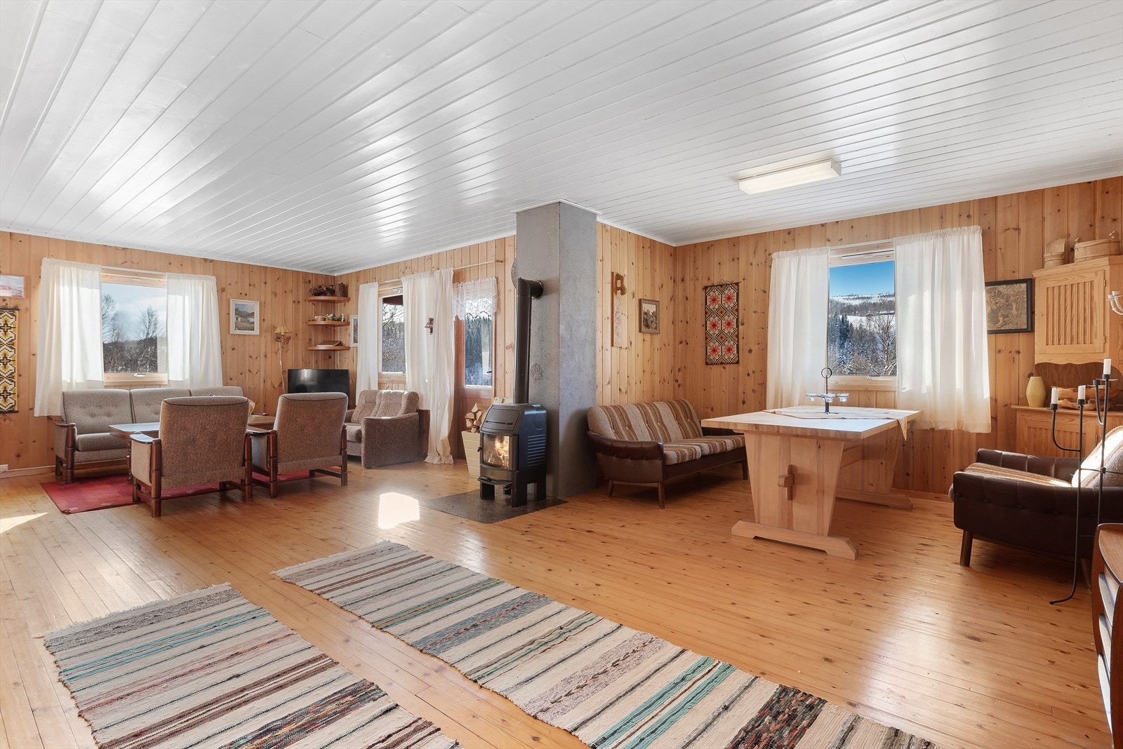 Stuen er naturlig inndelt i ulike brukssoner, og er innredet med spisebord ved kjøkkenet. Galleribilde