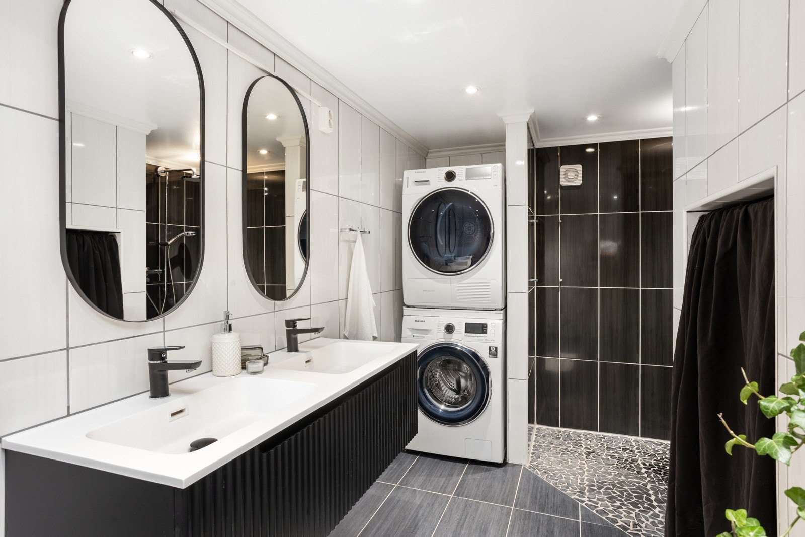 Stor plassbygget dusj samt opplegg for vaskemaskin og tørketrommel. Galleribilde