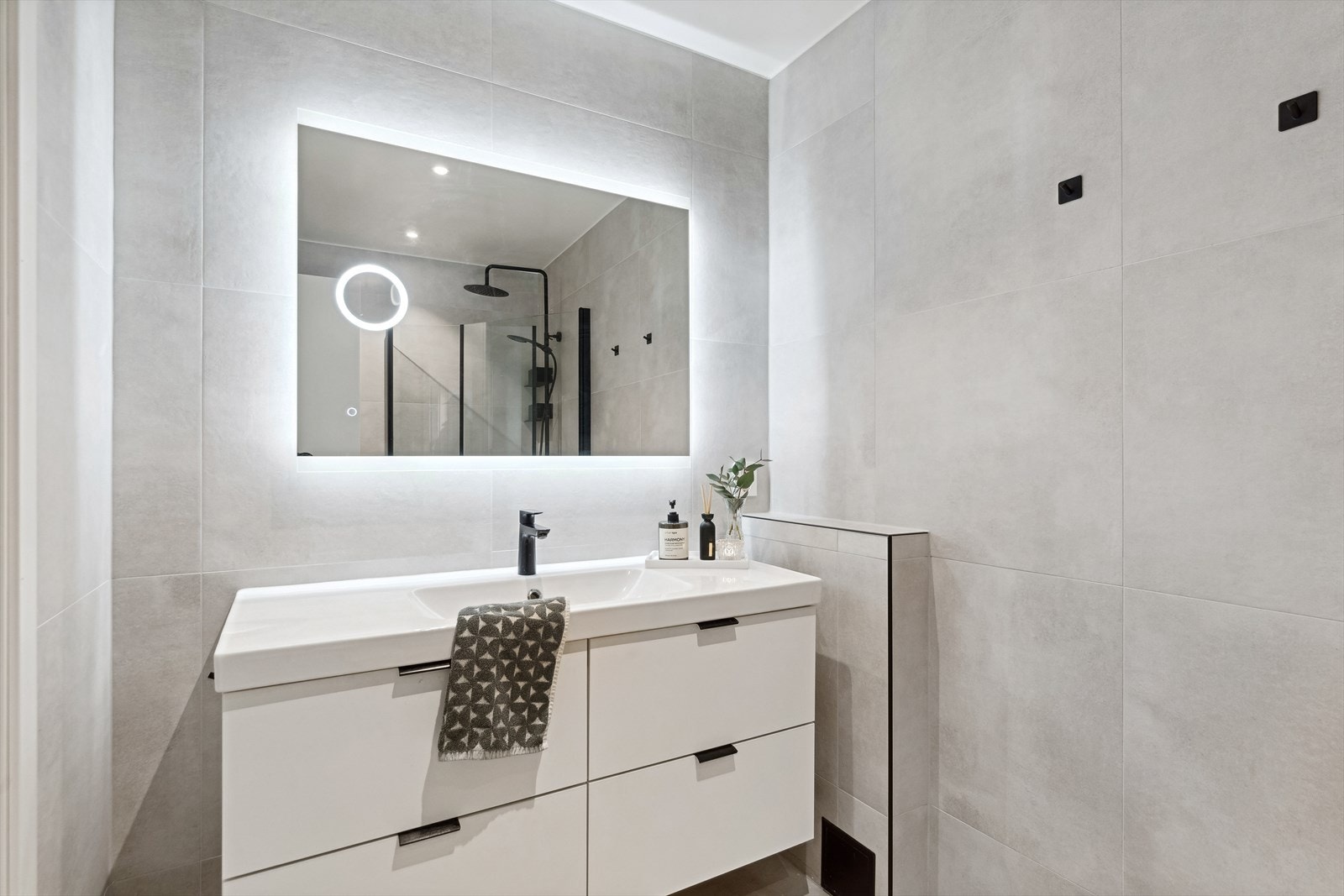 Dagene får en god start på et lekkert bad med store fliser med et eksklusivt inntrykk - badet ble pusset opp i 2022/23. Galleribilde