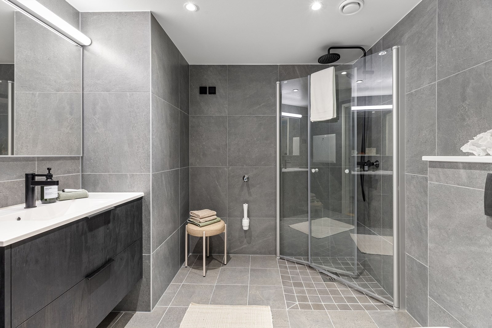 Innbydende og flislagt baderom med opplegg for vaskemaskin Galleribilde