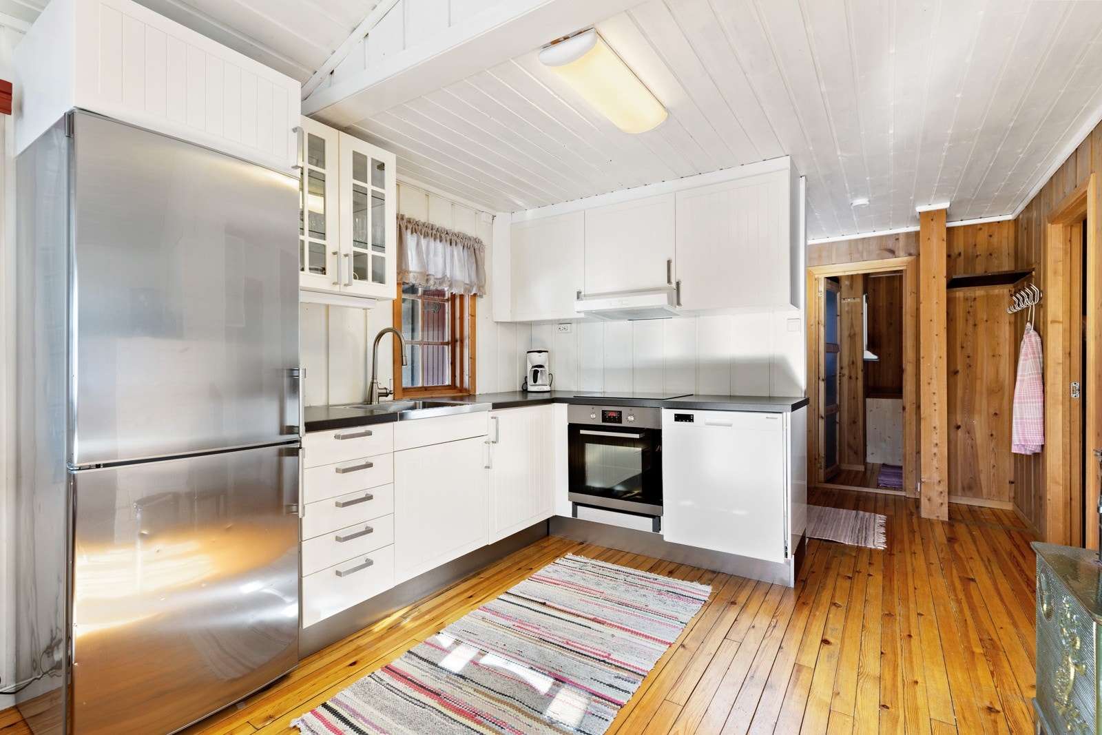 På kjøkkenet er det oppvaskmaskin, komfyr med platetopp samt kombinert kjøleskap og fryser. Godt med benkeplass og oppbevaring i skap. Galleribilde