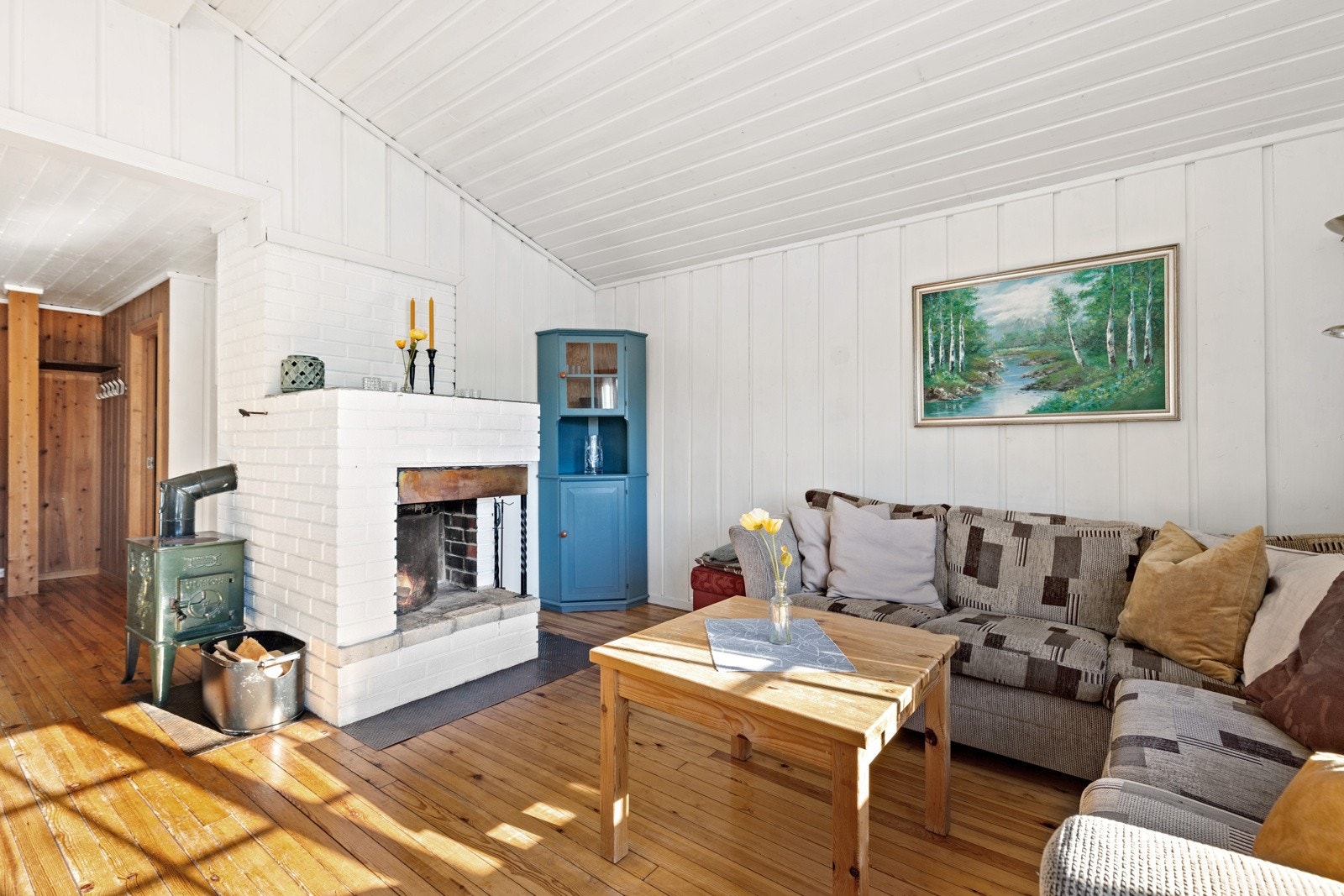 I stua er det både åpen peis og vedovn. Galleribilde