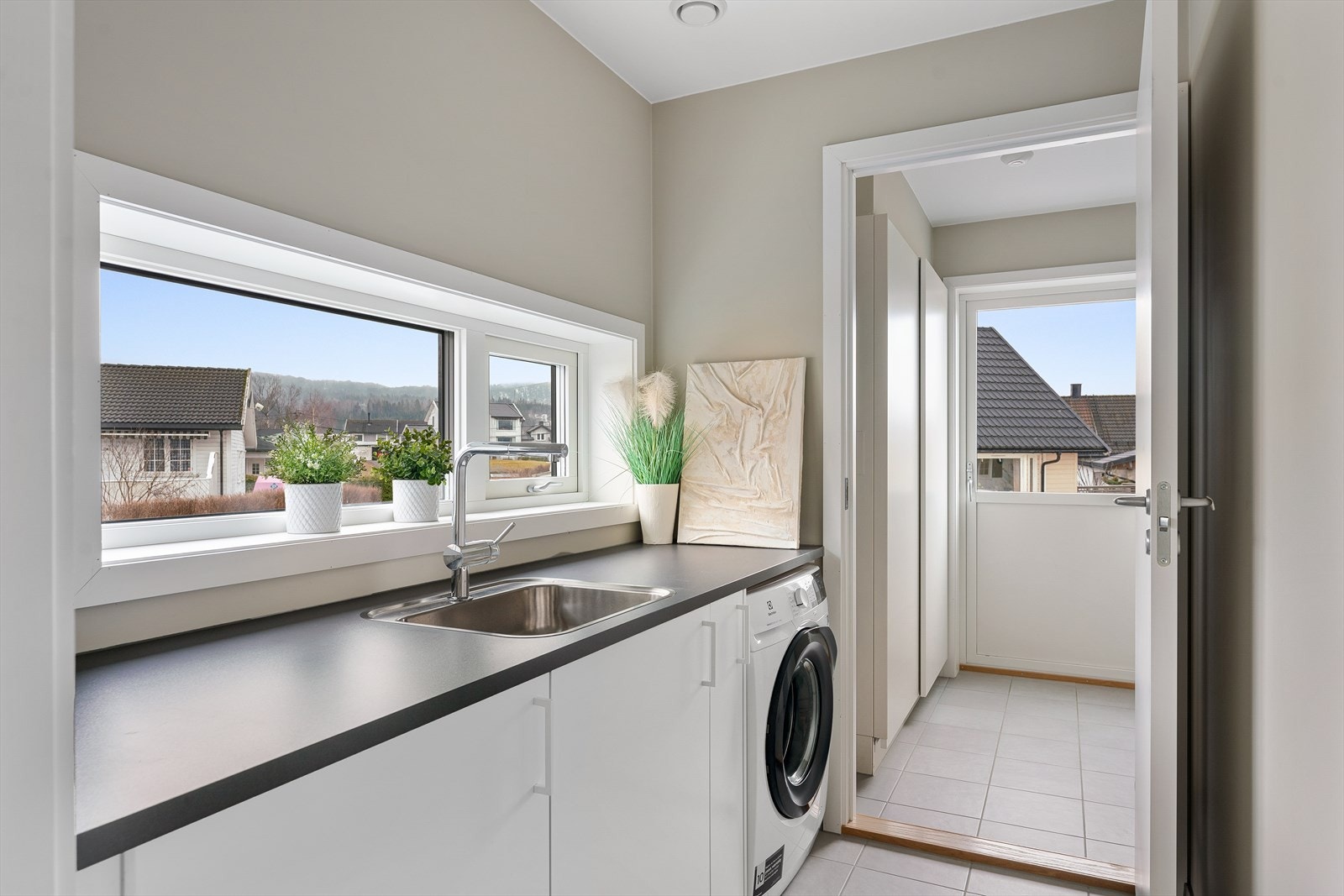Praktisk separat vaskerom med direkte adkomst til teknisk rom som har utgang til hage. Galleribilde