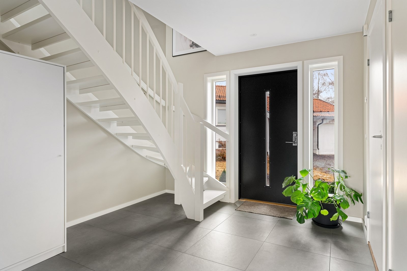 Lys og romslig entré med flislagt gulv med gulvvarme. Galleribilde