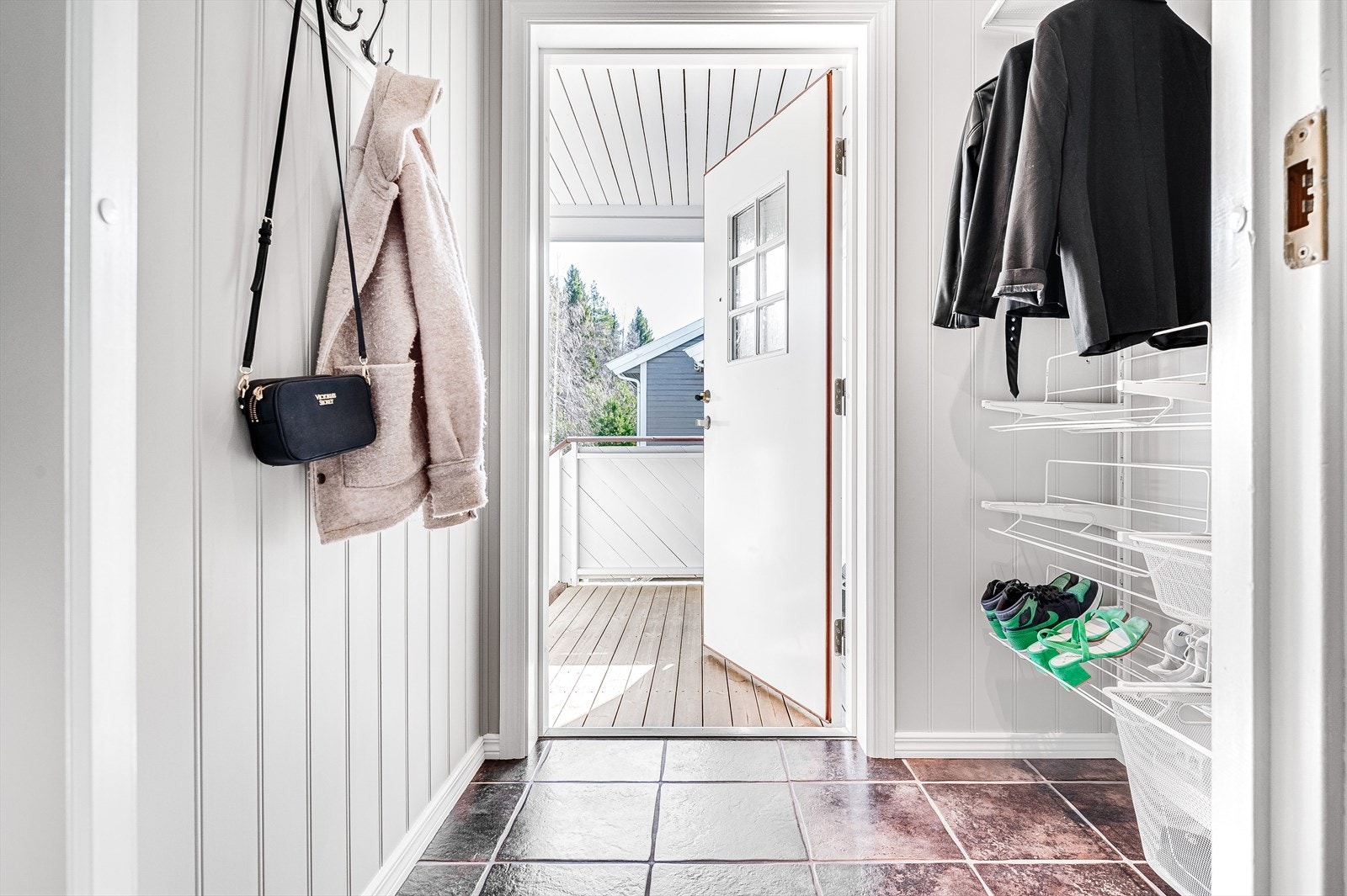 Du ønskes velkommen inn i en lys og praktisk entré med flislagt gulv. God plass til sko og yttertøy i åpen garderobeløsning. Galleribilde