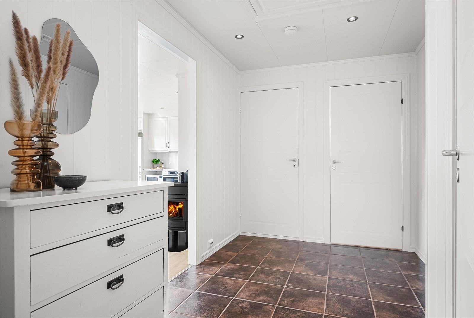 Fra entréen kommer du videre inn i en romslig gang med ytterligere plass til kommode eller garderobeskap. Gangen har flislagt gulv, lysmalteoverflater og downlights i himlingen. Galleribilde
