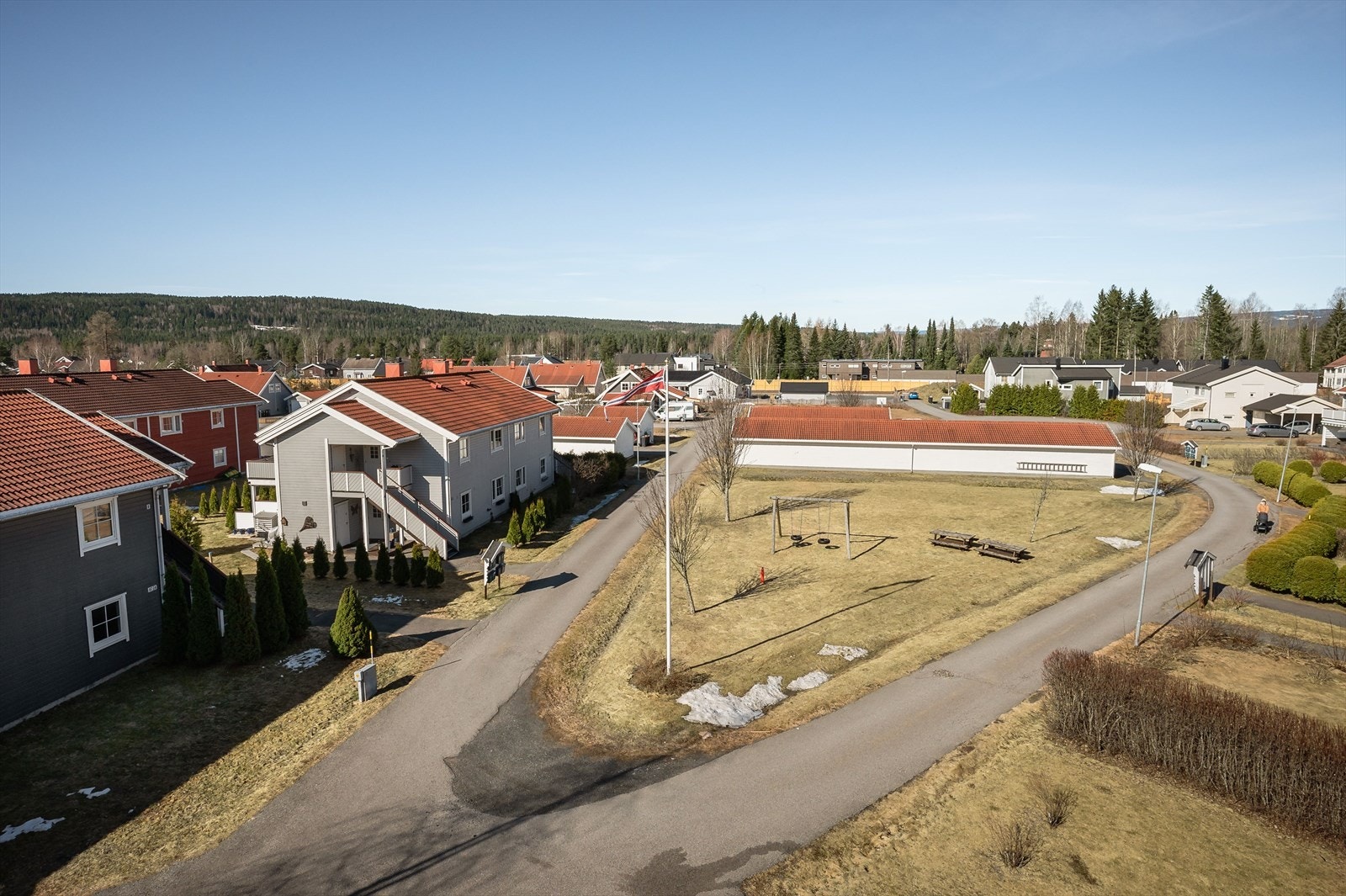 Tomten er opparbeidet med asfalterte veger, gressplen med variert beplantning, sittegrupper og huskestativ. Galleribilde