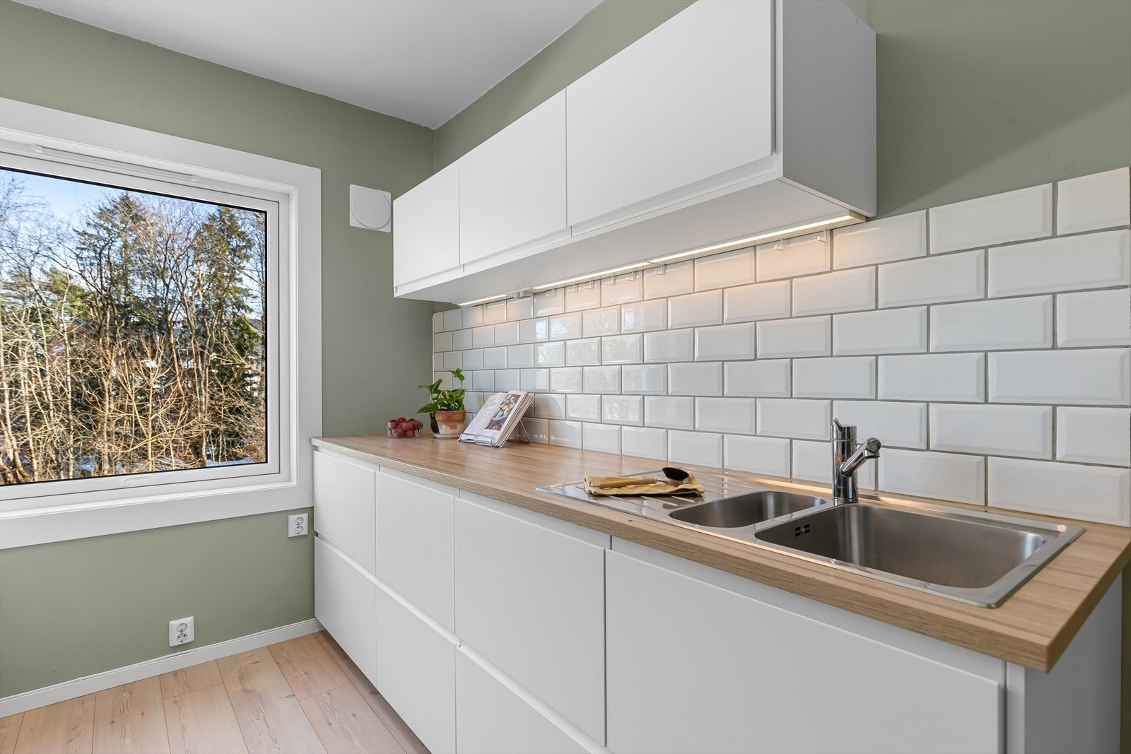 Praktisk innredning med lyse og glatte skapfronter skaper et moderne kjøkken. Galleribilde