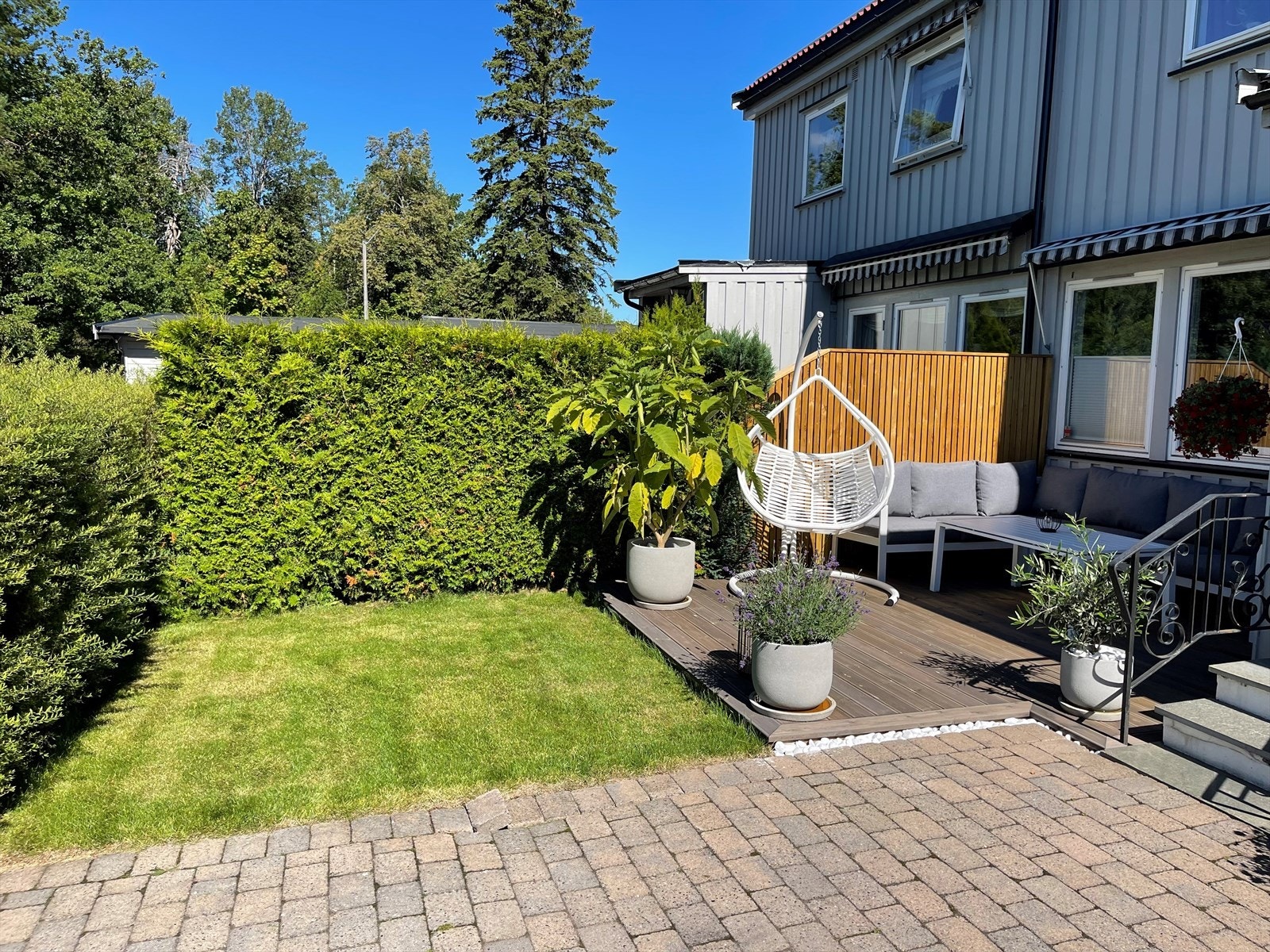Pent opparbeidet med en liten gressplen, terrasse og belegningsstein. Galleribilde