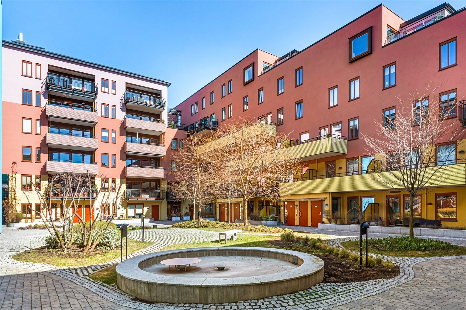 Nydelig bakgård med fontene, lekeapparat, beplantning m.m. Galleribilde