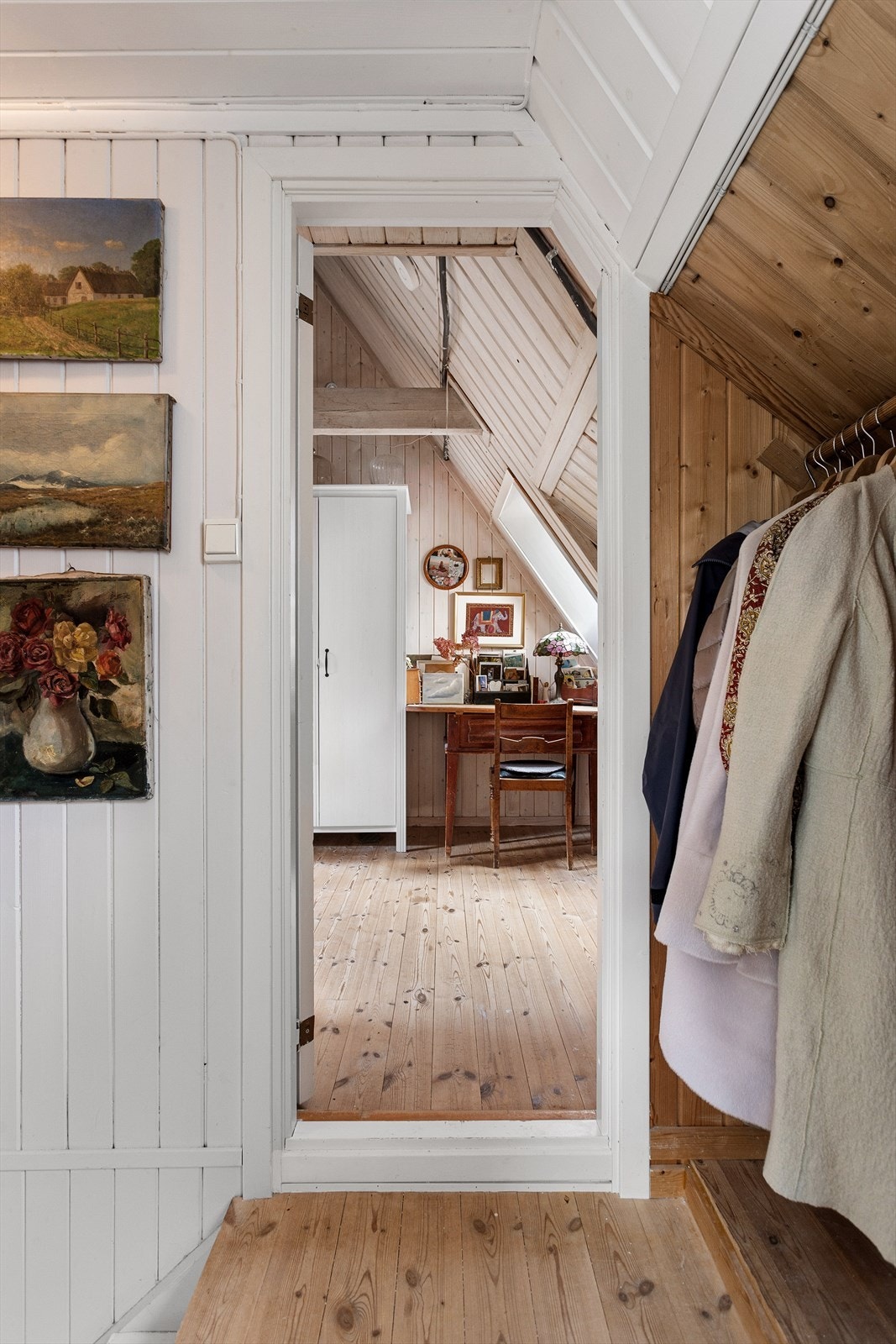 Fra trappen opp til loftet er det en liten mellomgang mellom soverommene med en praktisk oppbevaringsmulighet. Galleribilde