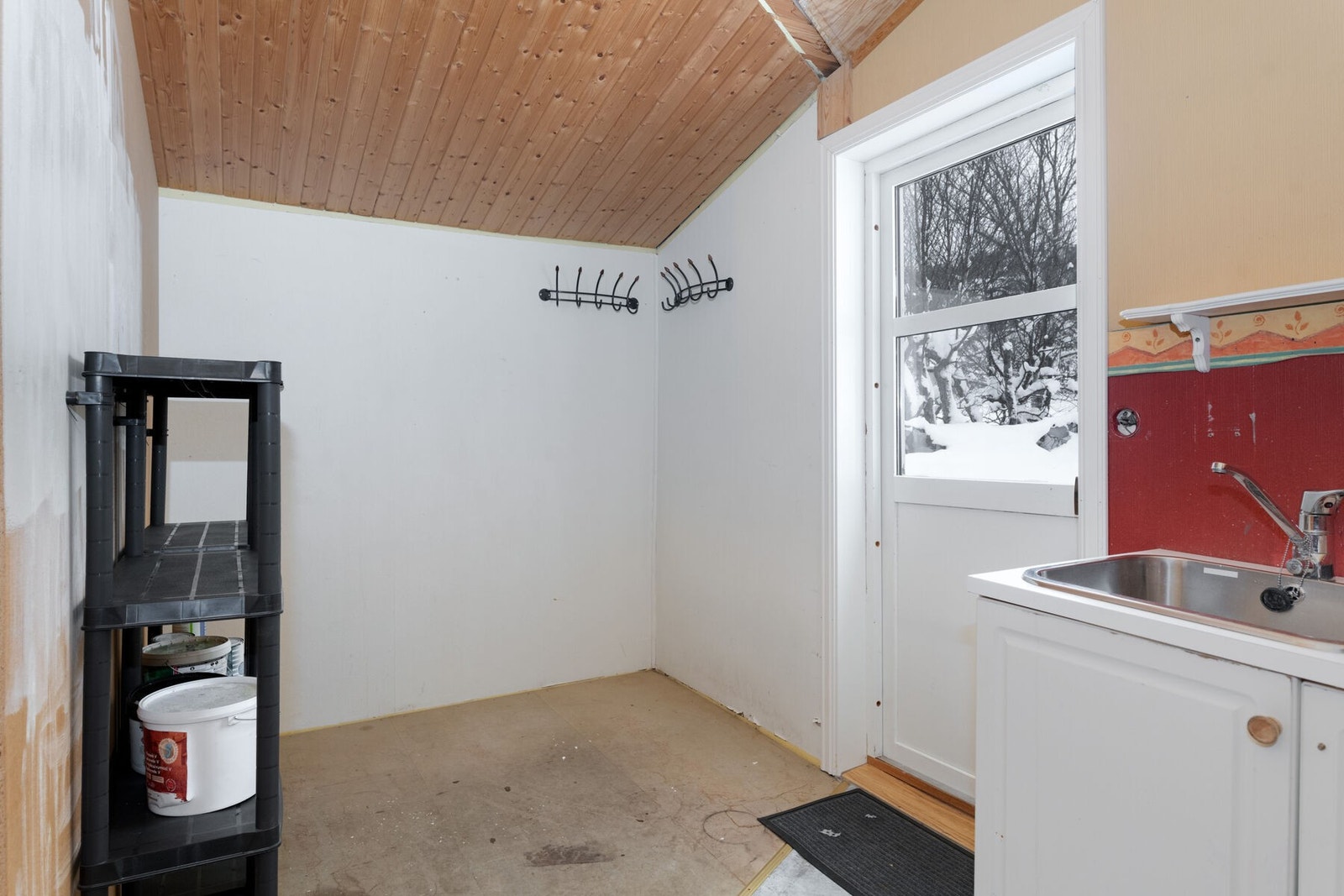 Fra entréen kommer man også inn til vaskerommet, utstyrt med skyllekar og opplegg for vaskemaskin. Galleribilde