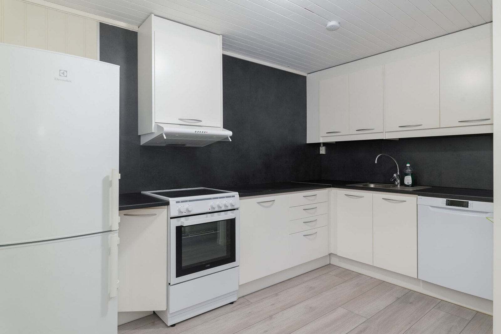 Nyere kjøkkeninnredning i underetasjen med slette fronter, benkeplate av laminat og opplegg for frittstående hvitevarer. Galleribilde