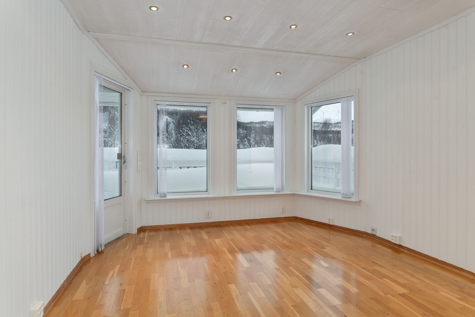 Del av stuen med spotbelysning i taket, og utgang til veranda. Galleribilde