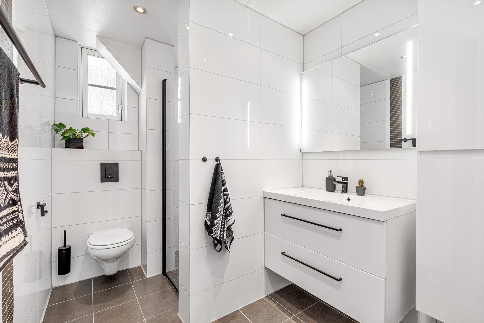 Delikat bad med smakfulle flisvalg og moderne innredning som gir et harmonisk og helheltlig inntrykk. Galleribilde