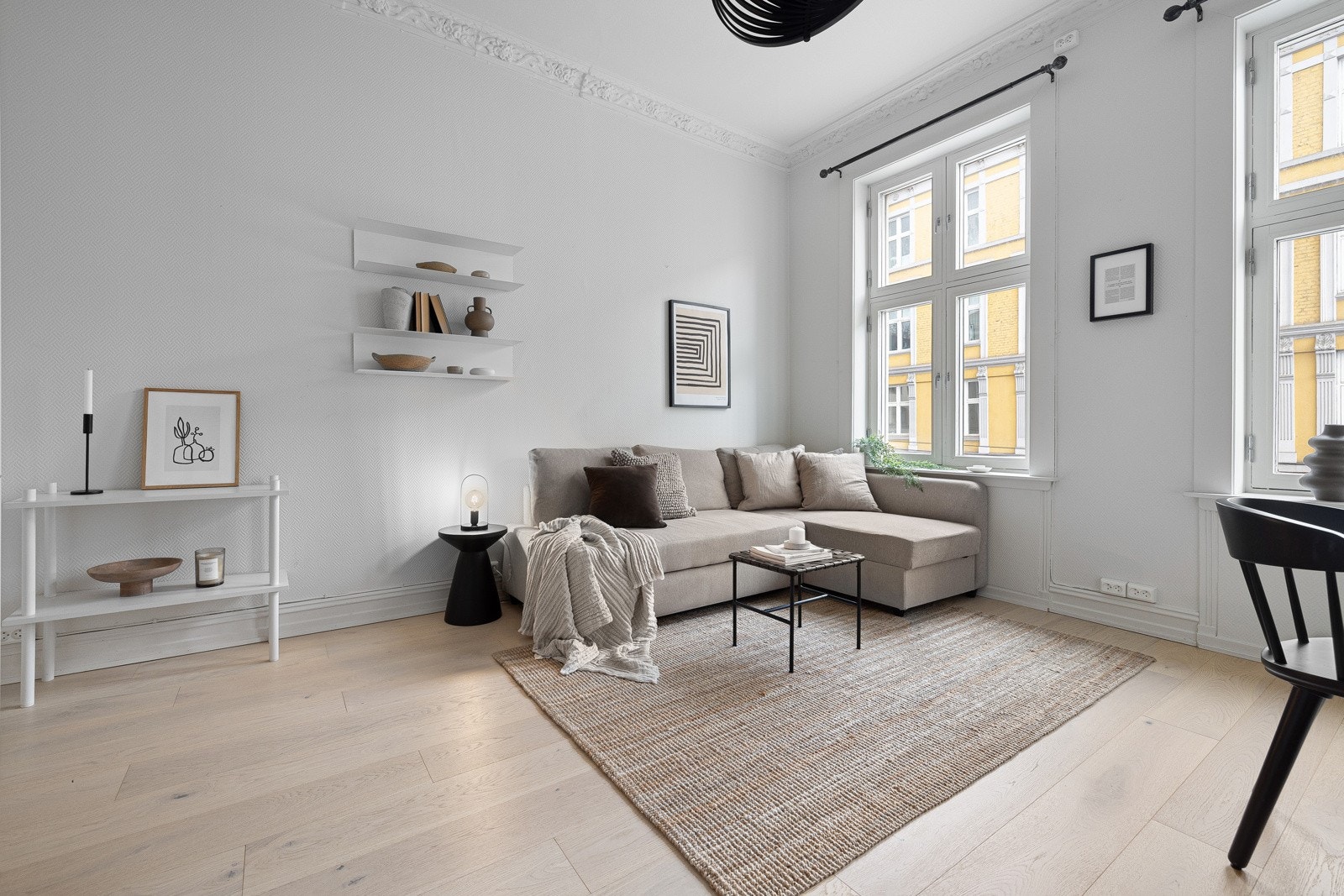 Lys stue med plass til sofagruppe, sofabord og underholdningsavdeling. Galleribilde