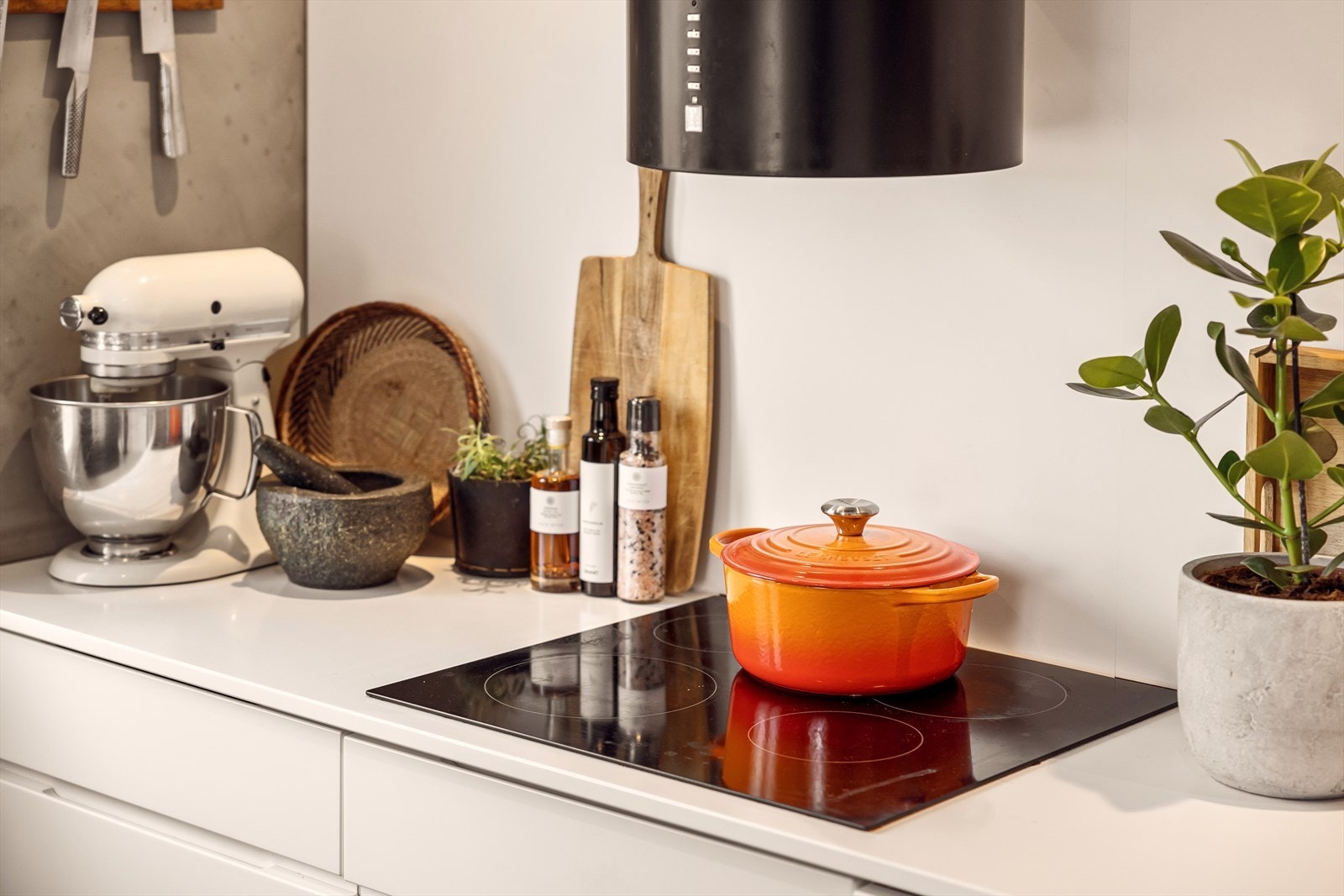 Pent kjøkken med grepsløse hvite fronter og kompositt benkeplate med nedfelt vaskekum. Galleribilde