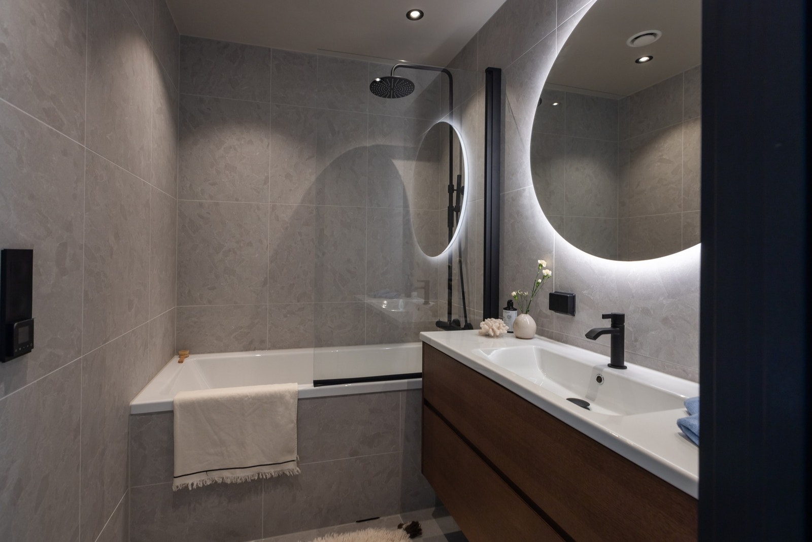 Badet tilknyttet de tre soverommene i hovedetasjen har de samme beige-tonede flisene som badet i andre etasje, og er innredet med praktisk baderomsmøbel med skuffer og heldekkende servant, innmurt badekar med dusj og vegghengt toalett. Galleribilde