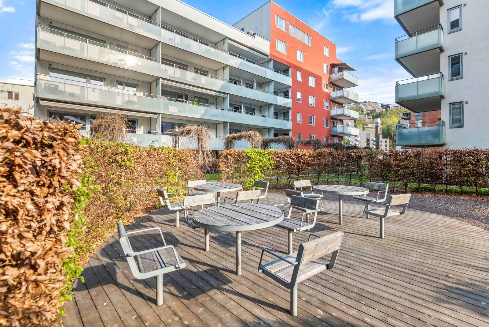 Velstelte fellesarealer som inkluderer store, grønne områder med beplantning og hyggelige sittegrupper Galleribilde