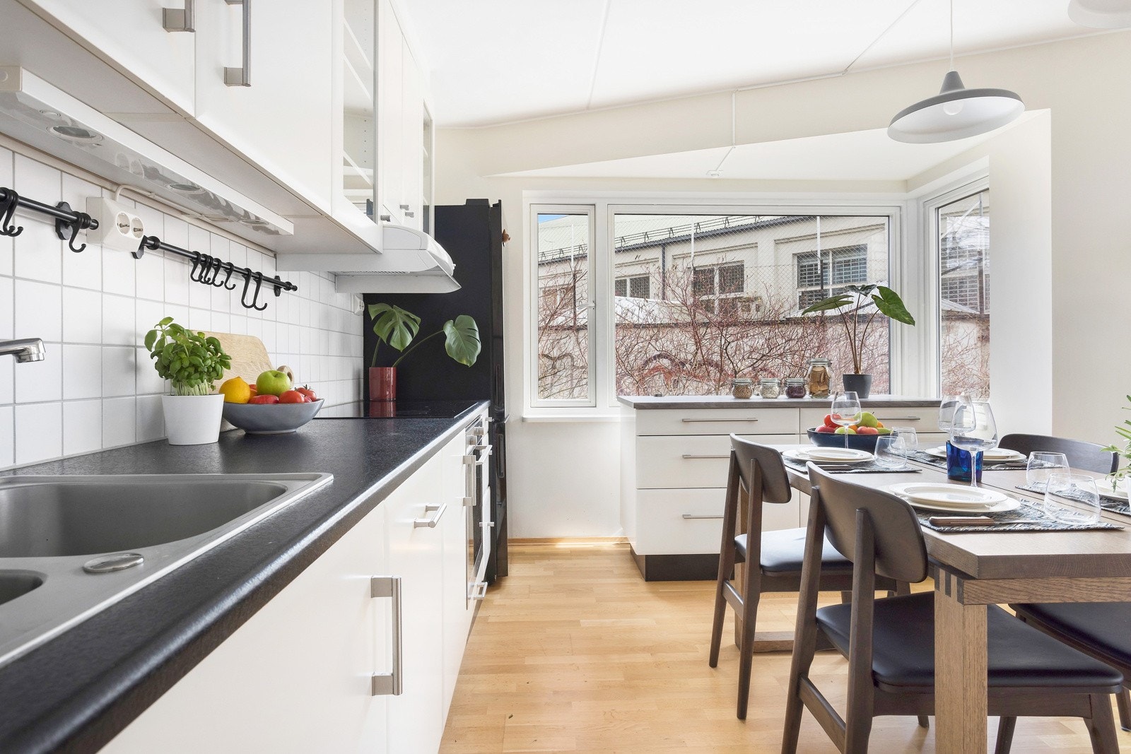 Kjøkkenet er innredet langs veggene med flytende kjøkkenøy plassert under vinduet Galleribilde