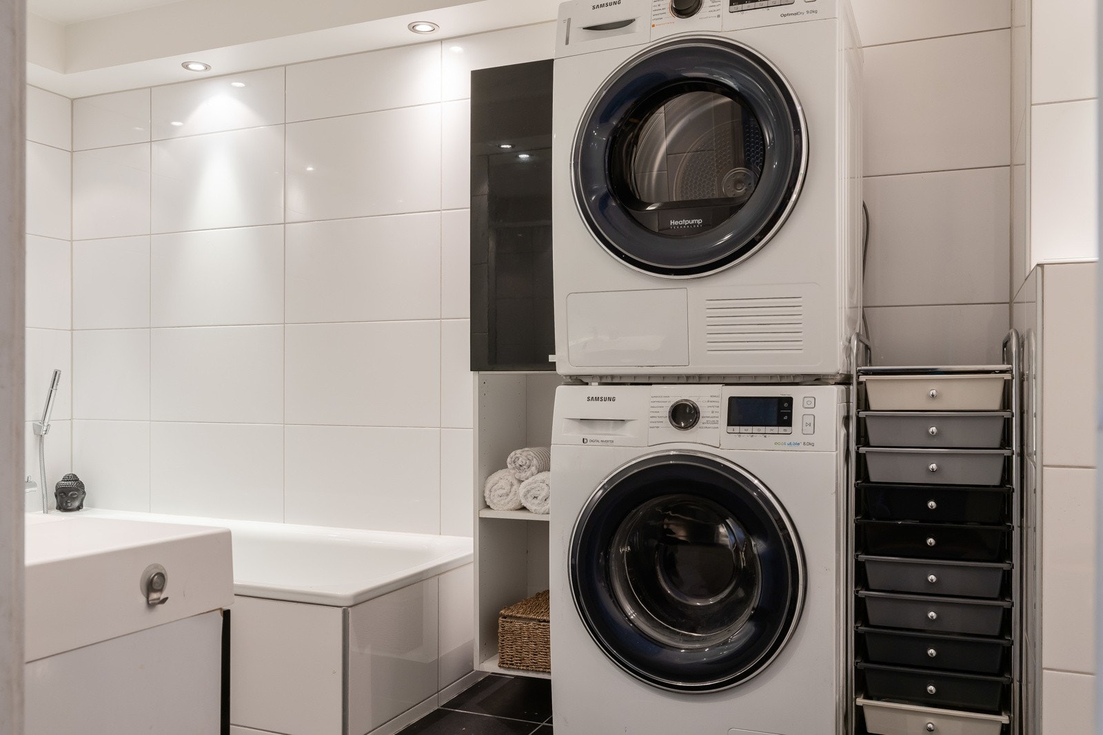 Badet er utstyrt med badekar, opplegg for vaskemaskin, veggmontert toalett, servantskap, dusjhjørne og innfellbare dusjdører. Galleribilde