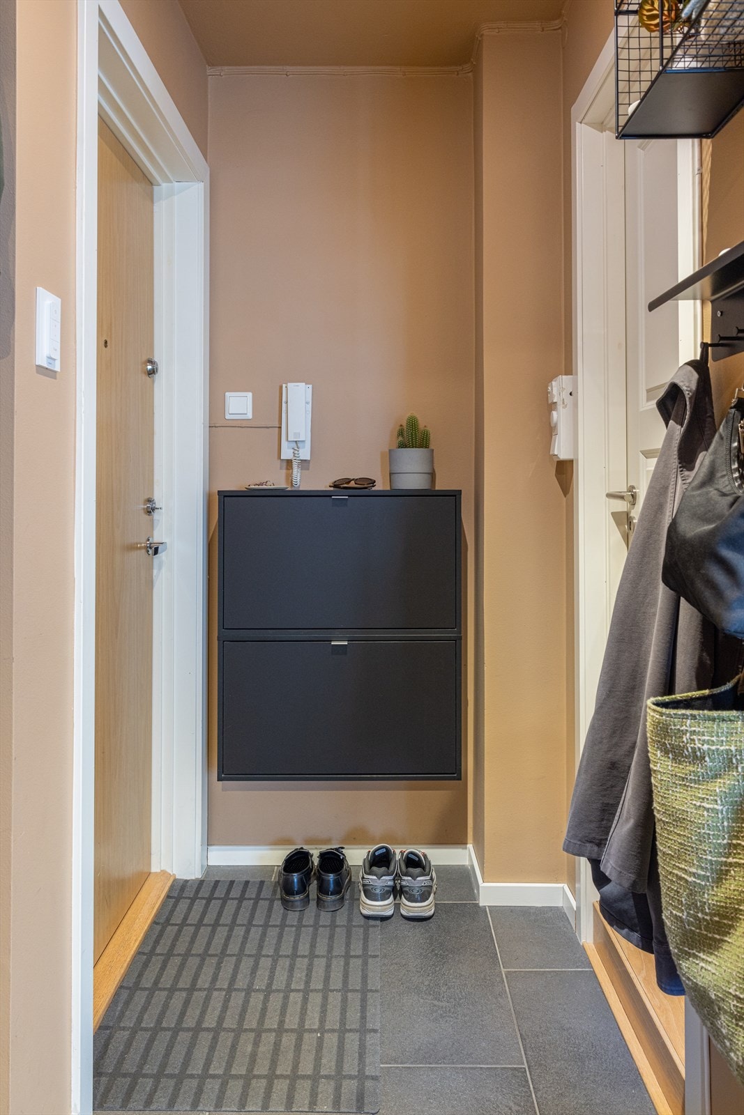 leiligheten blir du møtt av en innbydende entré med flislagt gulv og malte vegg- og himlingsflater i lune farger Galleribilde