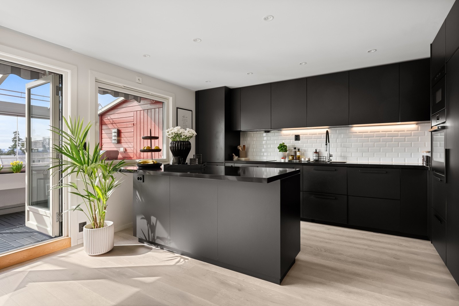 Lekkert kjøkken med integrerte hvitevarer og kjøkkenøy Galleribilde