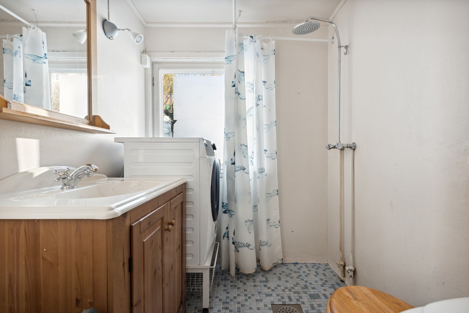 Baderom II - Baderommet er innredet med dusj, enkel servantløsning med underskap, gulvstående toalett, samt opplegg for vaskemaskin Galleribilde