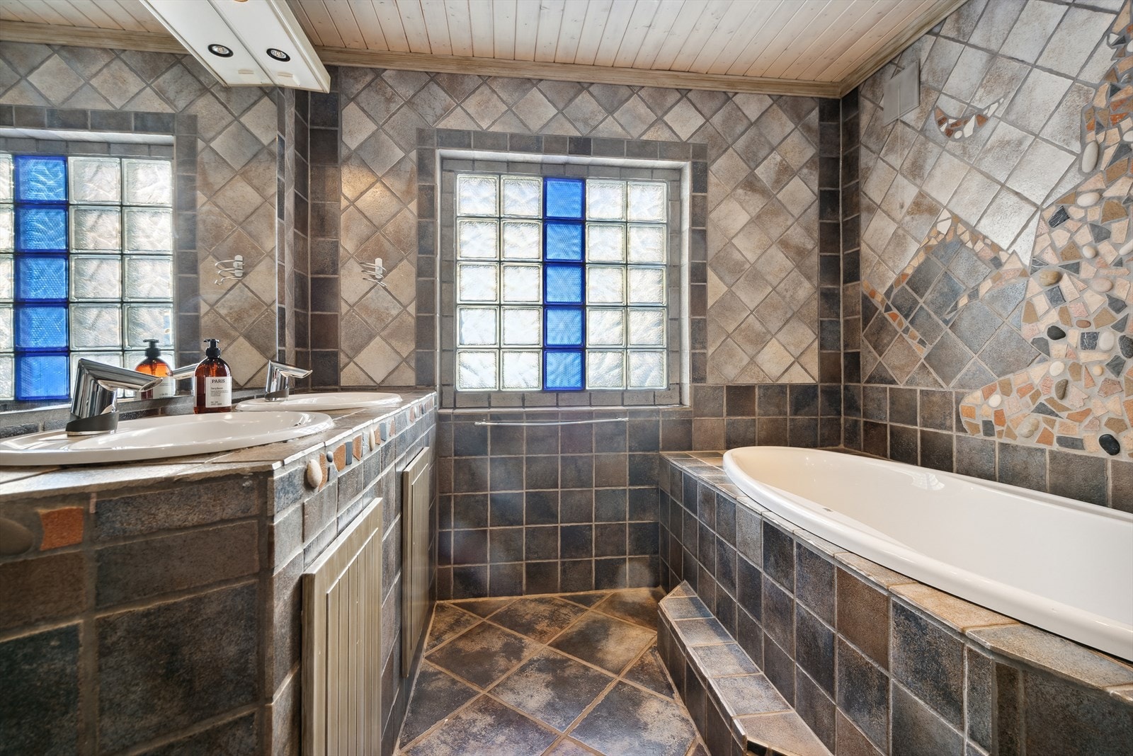 Bad I - Romslig baderom innredet med badekar, dobbel servantløsning med underskap, vegghengt toalett m.m. Galleribilde