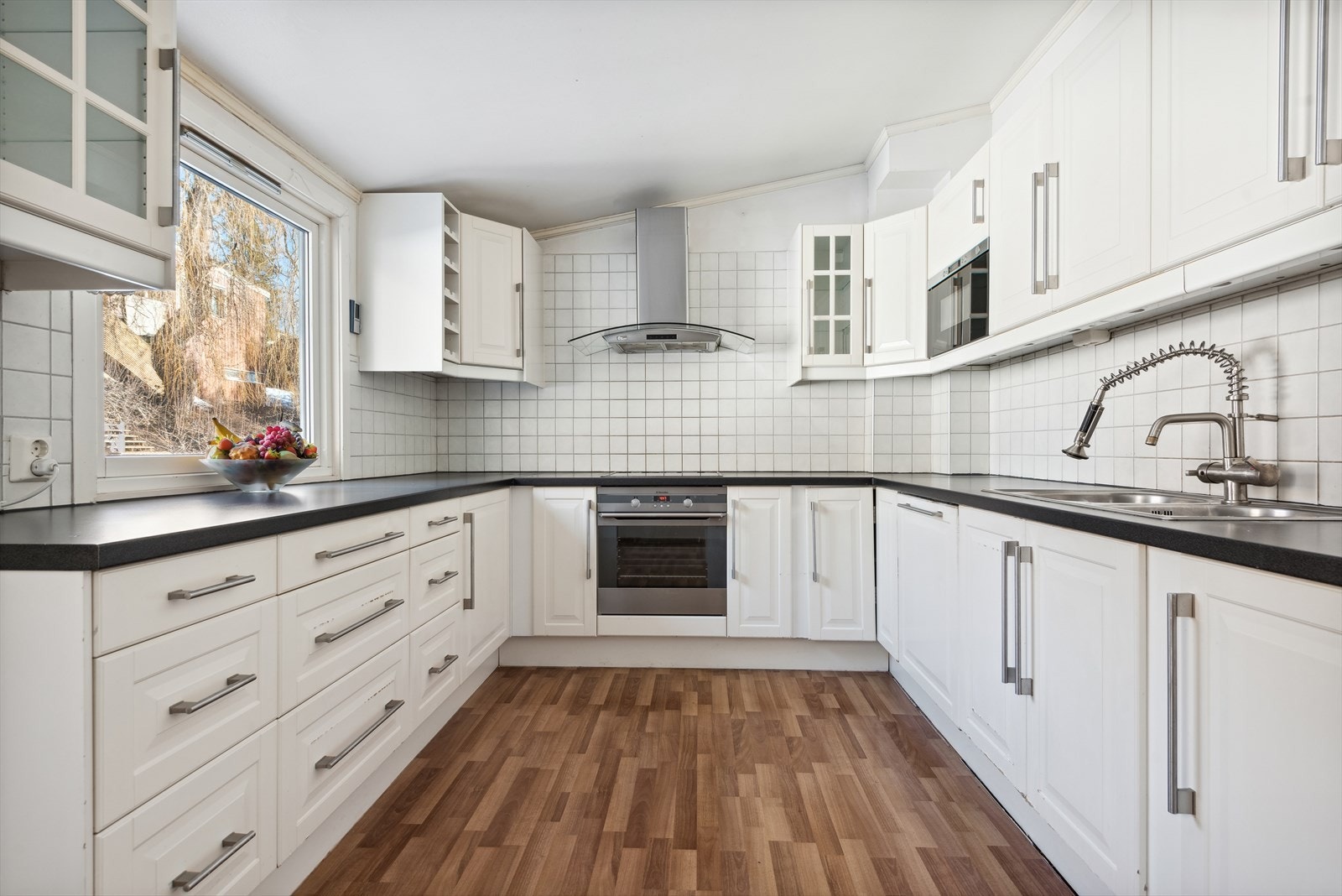 Lys kjøkkeninnredning fra 2009, med integrerte hvitevarer som stekeovn, keramisk topp, mikrobølgeovn og oppvaskmaskin Galleribilde