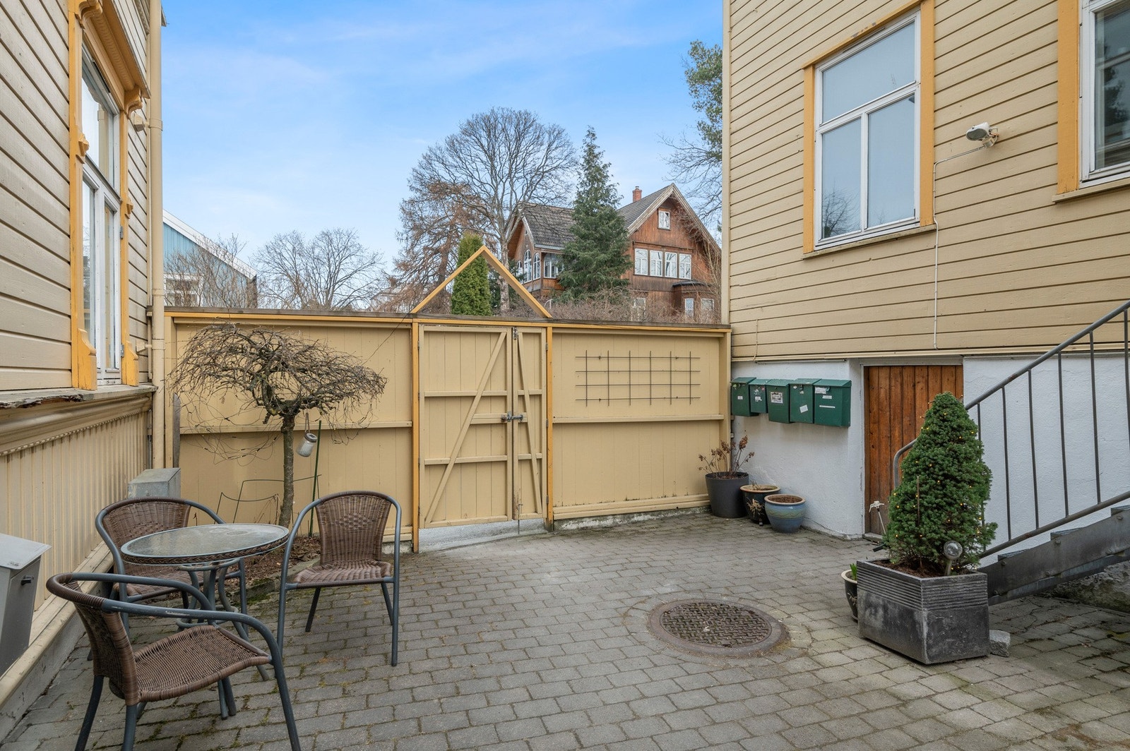 Lukket og skjermet bakgård med trivelige og pent opparbeidede fellesområder med sittegrupper og beplantning. Galleribilde