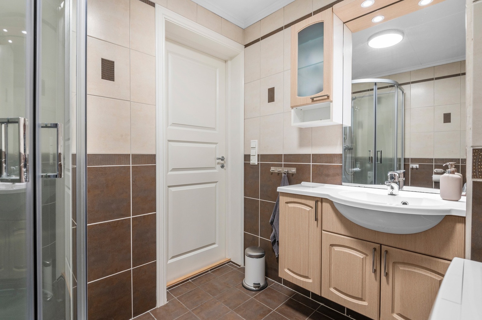 Delikat flislagt bad med romslig baderomsinnredning Galleribilde