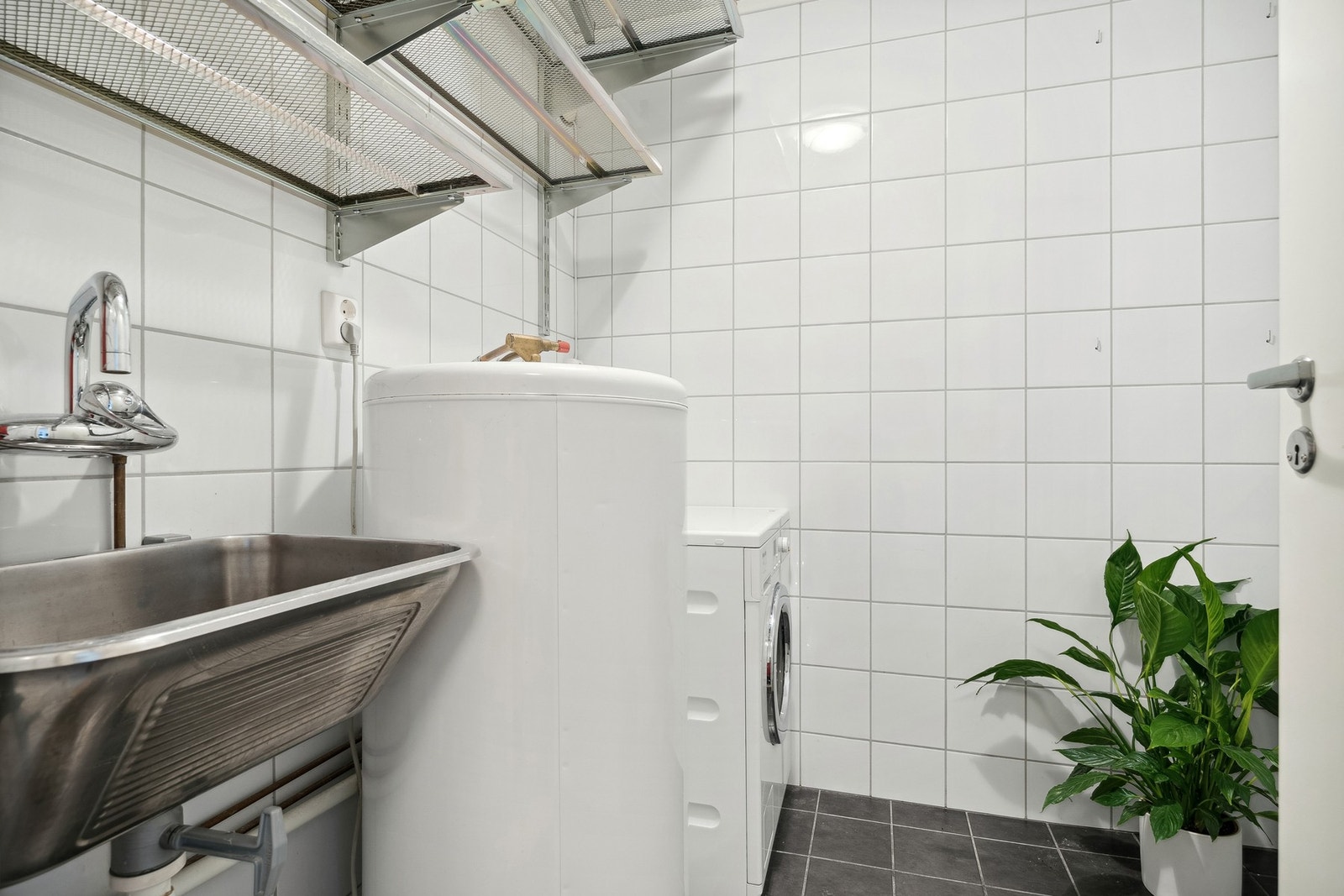 Vaskerommet har kran og avløp for vaskemaskin, varmtvannsbereder, vaskekar og diverse hyller. Galleribilde