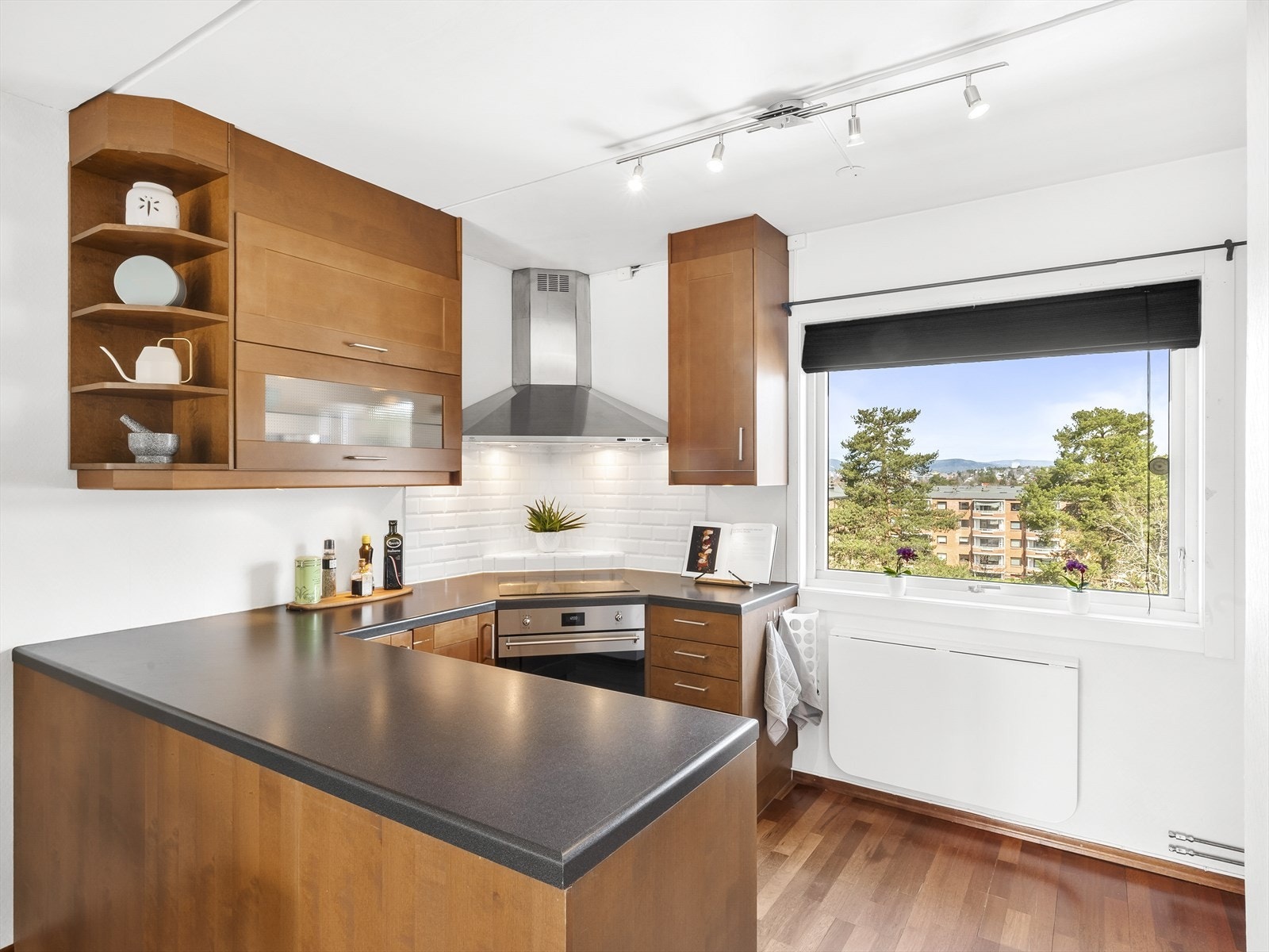 Romslig og praktisk kjøkken med parkett på gulv, malte vegger og malt tak. Galleribilde