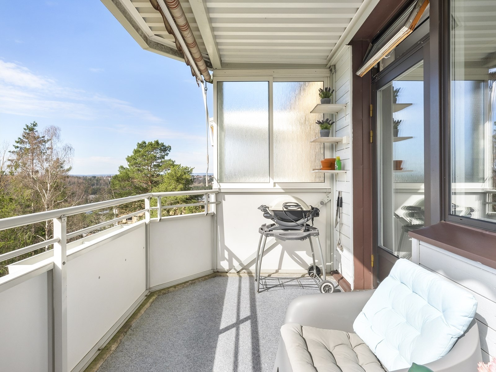 Fra stue er det utgang til en meget hyggelig sydvendt balkong på 7m² med balkongteppe på gulv, markise og utsikt mot friområde/skogen. Galleribilde