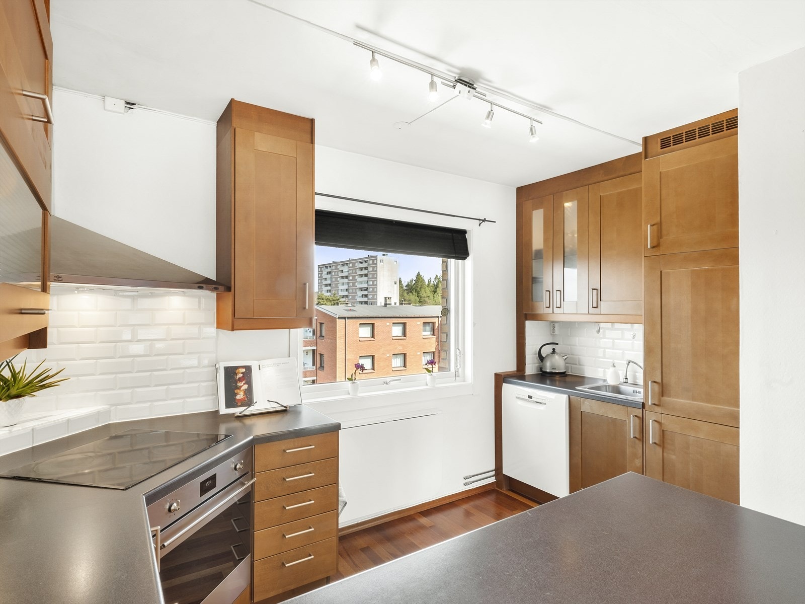 Kjøkkeninnredning med kirsebærfronter, 3 stk. fronter med glass, laminat benkeplate med fliser over, enkel oppvaskkum, ventilator i stål, opplegg for oppvaskmaskin samt integrert stekeovn, koketopp og kjøl-/fryseskap. Muligheter for sitteplass ved kjøkken Galleribilde