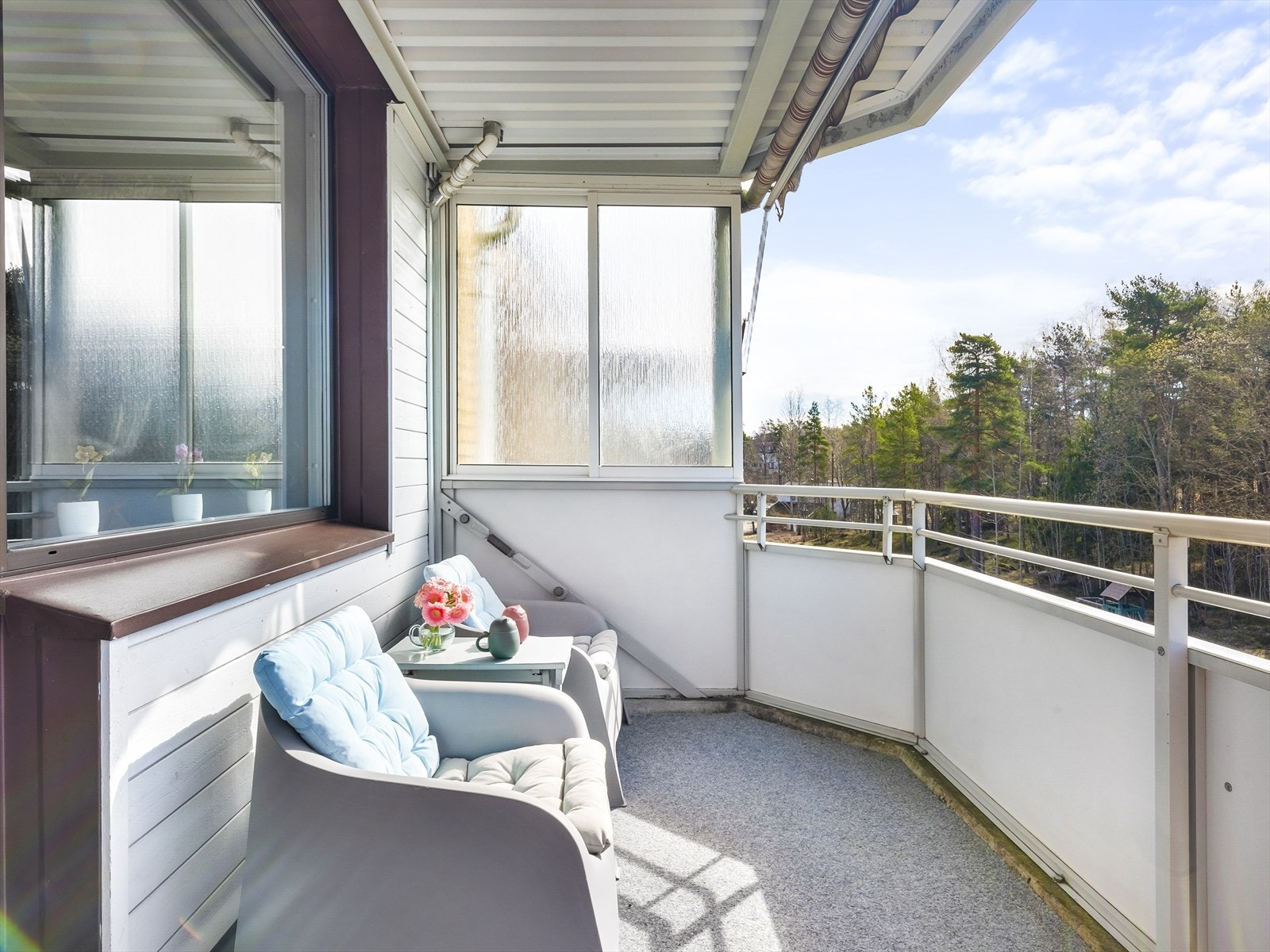 Fra stue er det utgang til en meget hyggelig sydvendt balkong på 7m² med balkongteppe på gulv, markise og utsikt mot friområde/skogen. Galleribilde