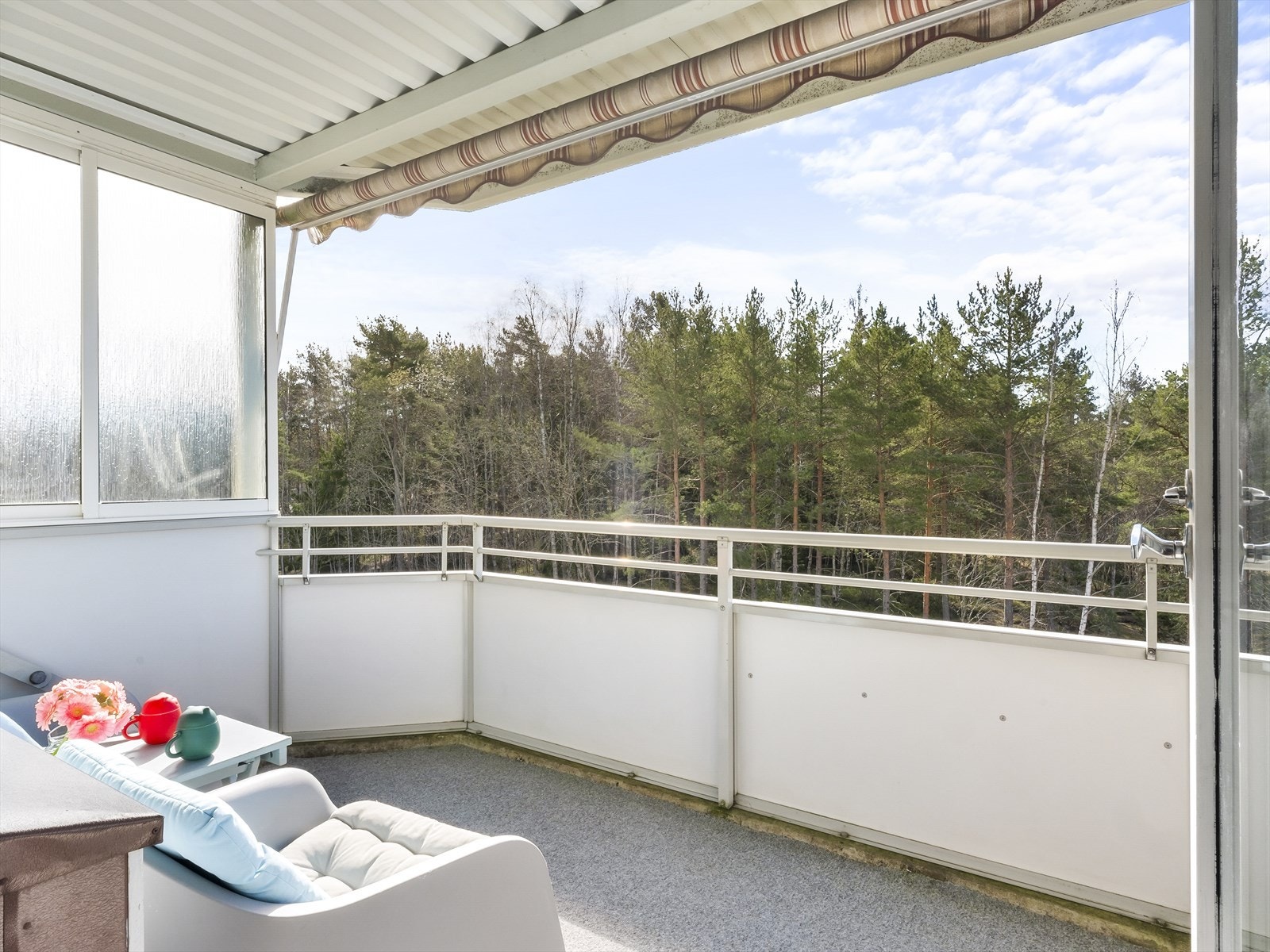 Fra stue er det utgang til en meget hyggelig sydvendt balkong på 7m² med balkongteppe på gulv, markise og utsikt mot friområde/skogen. Galleribilde