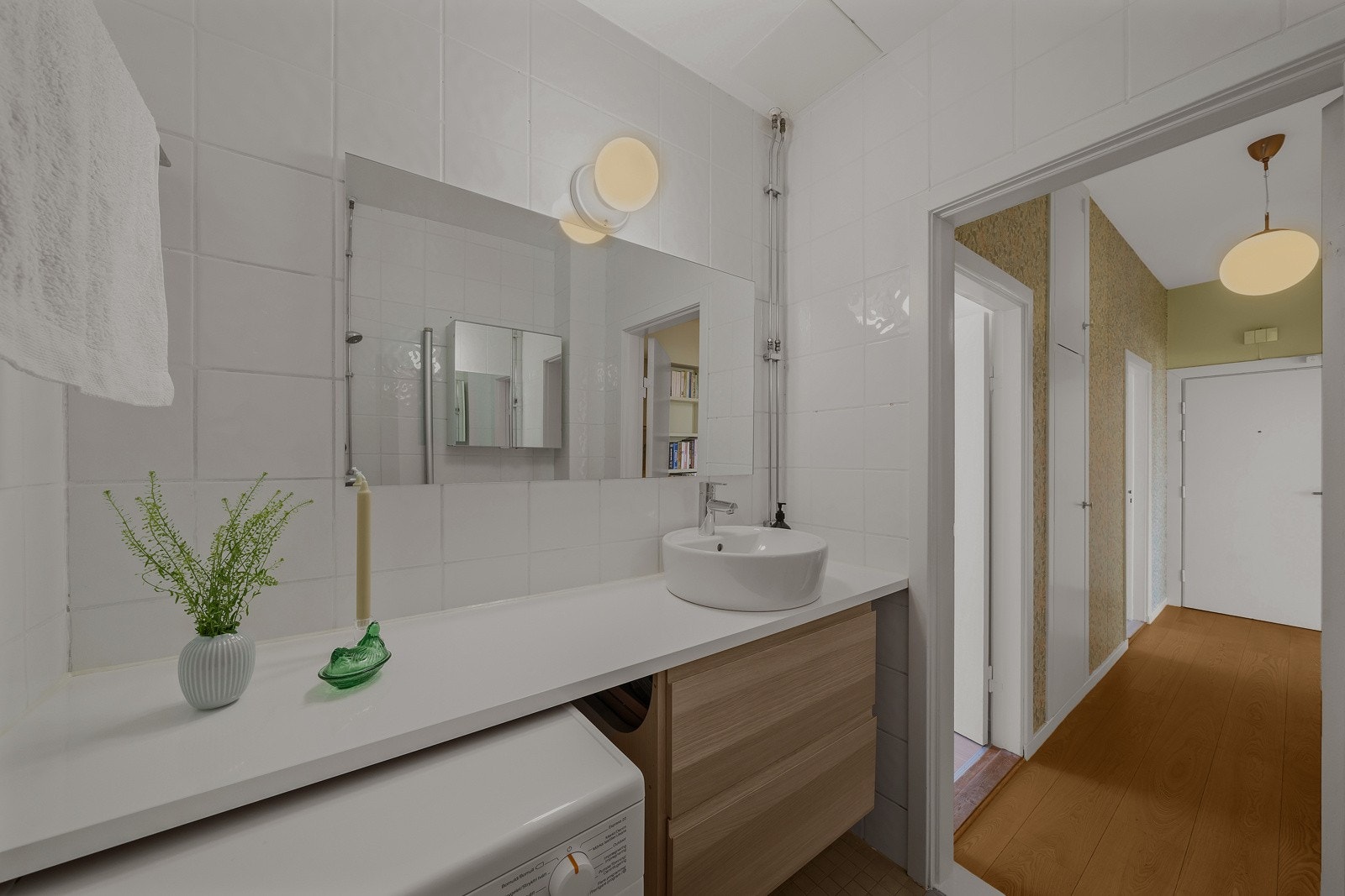 Det er utstyrt med skuffeseksjon med finerte fronter og en hvit benkeplate med toppmontert servant. Galleribilde