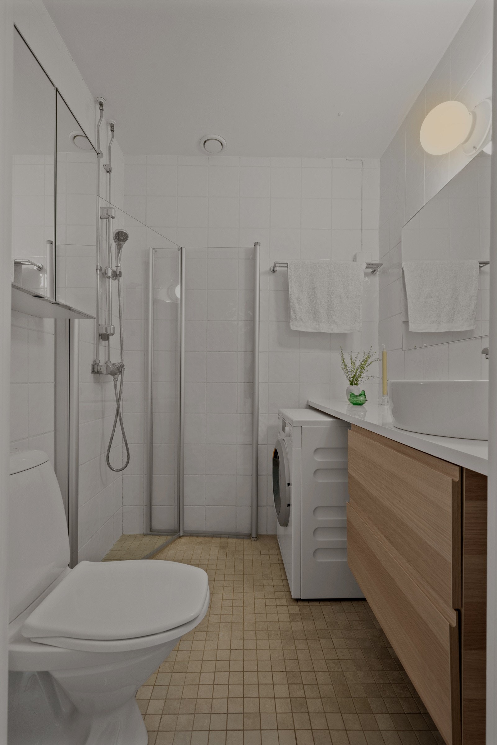 Det er opplegg for vaskemaskin. Videre har badet et toalett og et dusjhjørne med innfellbare glassdører. Galleribilde