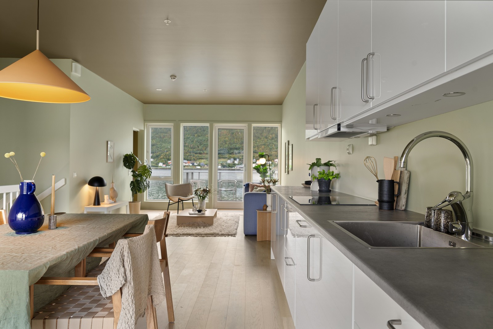 I boligens hovedplan kommer du til boligens høydepunkt - nemlig stue og kjøkken. Rommet framstår åpent, lyst og luftig, med store vindusflater og generøs takhøyde.
