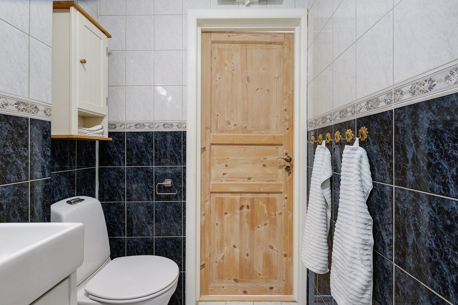 Badet inneholder glatt baderomsinnredning med servant nedfelt i underskap, speil med lys, dusjkabinett, toalett og opplegg til vaskemaskin. Galleribilde